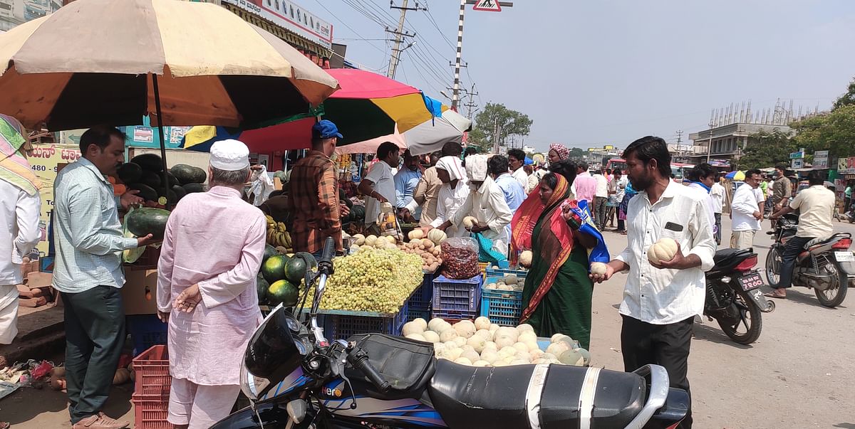 ದೇವದುರ್ಗ ಪಟ್ಟಣದಲ್ಲಿ ಬಿರು ಬಿಸಿಲಿನಲ್ಲಿ ಯುಗಾದಿ ಹಬ್ಬದ ಬೇವಿನ ಹೆಚ್ಚ ಮತ್ತು ಹಣ್ಣು ಖರೀದಿಸುತ್ತಿರುವ ಜನರು