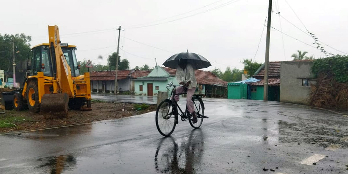 ಯಳಂದೂರು ತಾಲ್ಲೂಕಿನ ಮದ್ದೂರು-ಆಲ್ಕೆರೆ ಅಗ್ರಹಾರ ಗ್ರಾಮದಲ್ಲಿ ಸೋಮವಾರ ಸುರಿದ ಮಳೆ ನಡುವೆ ಸೈಕಲ್ ಏರಿ ಹೊರಟ ವಿದ್ಯಾರ್ಥಿ