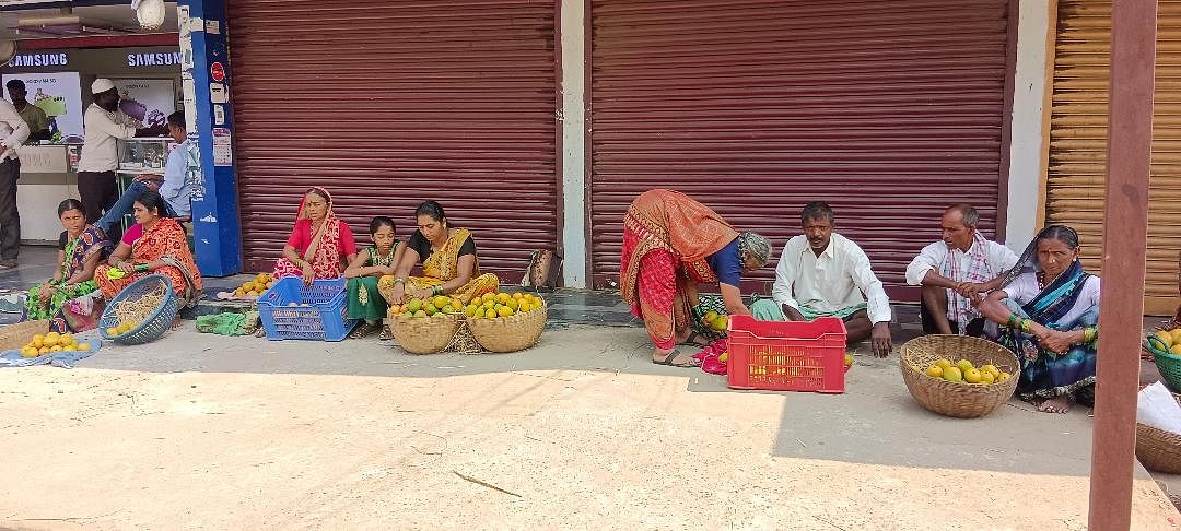 ಹಳಿಯಾಳದ ಸಾರಿಗೆ ನಿಲ್ದಾಣದ ಹತ್ತಿರ ಮಾವಿನ ಹಣ್ಣುಗಳನ್ನು ಮಾರಾಟ ಮಾಡುವವರು ಗ್ರಾಹಕರಿಗಾಗಿ ಕಾಯುತ್ತಾ ಕುಳಿತಿರುವುದು.