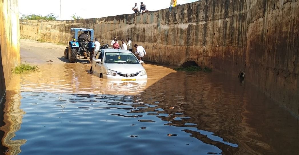 ಚಿಕ್ಕಜಾಜೂರು ಸಮೀಪದ ಅಮೃತಾಪುರದ ರೈಲ್ವೆ ನಿಲ್ದಾಣದ ಬಳಿಯ ರೈಲ್ವೆ ಕೆಳ ಸೇತುವೆಯಲ್ಲಿ ಸಿಲುಕಿದ ಕಾರನ್ನು ಟ್ರ್ಯಾಕ್ಟರ್ ಮೂಲಕ ಎಳೆಯುತ್ತಿರುವುದು