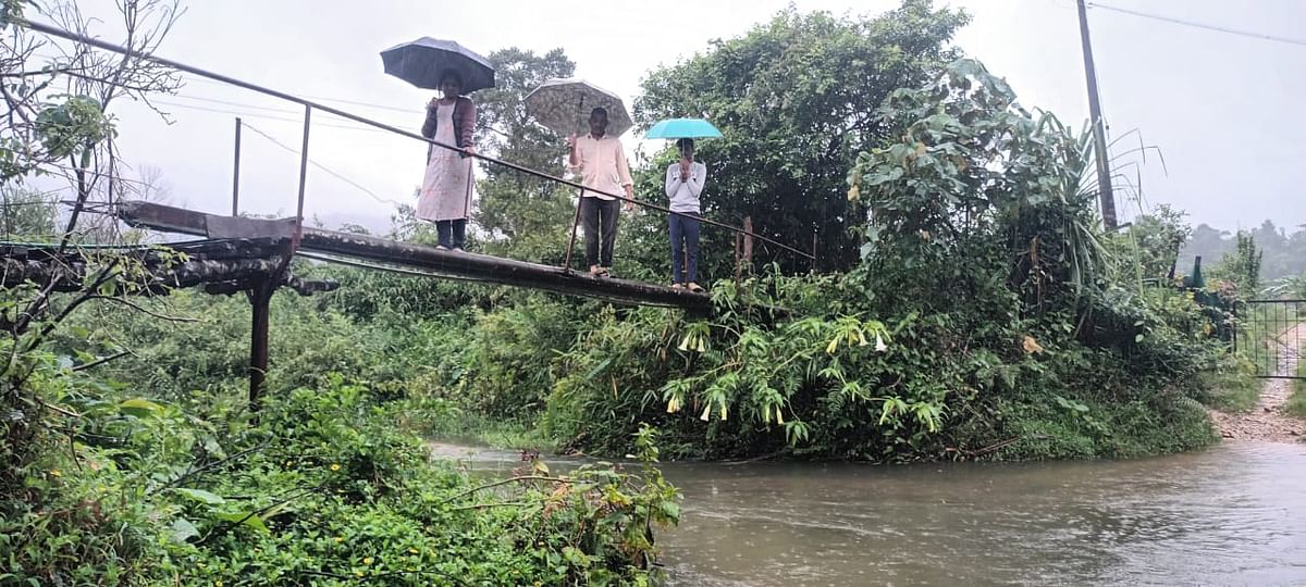 ತರುವೆ ಗ್ರಾಮದ ಸುರೇಶ್ ನಾಯ್ಕ್ ಕುಟುಂಬ ಜೀವ ಭಯದಲ್ಲೇ ಕಾಲು ಸಂಕದ ಮೇಲೆ ನಿಂತಿರುವುದು