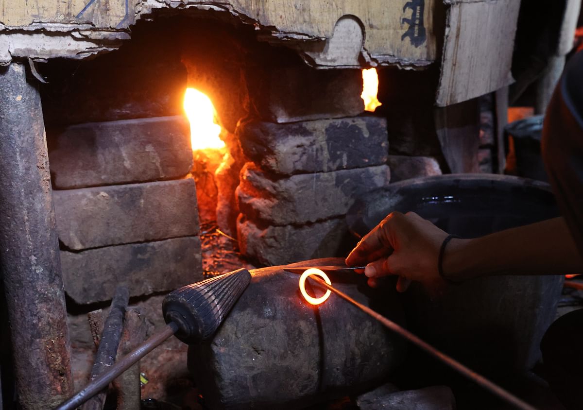 ಬೆಂಕಿಯಲ್ಲಿ ಕಾದ ಗಾಜು ಬಳೆಯ ರೂಪ ಪಡೆಯುತ್ತಿರುವುದು