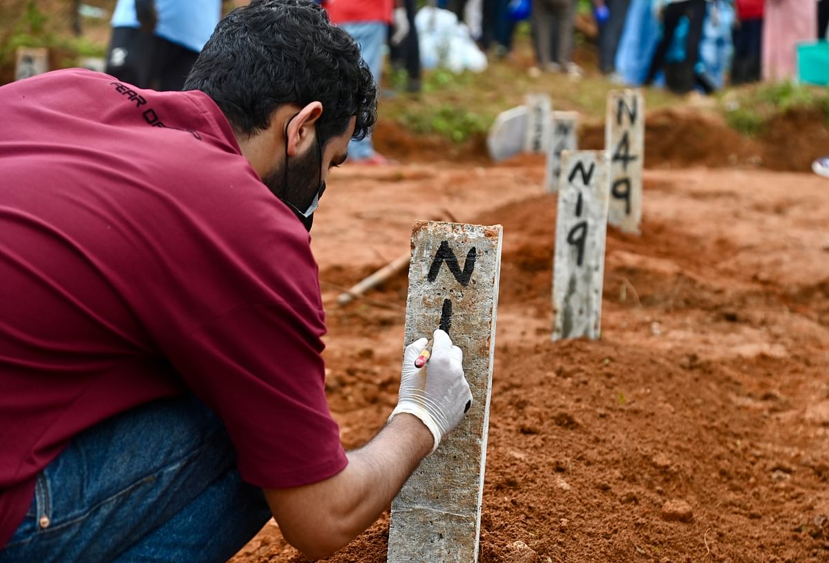 ಭೂಕುಸಿತದಿಂದ ಸಾವಿಗೀಡಾದವರ ಪೈಕಿ ಗುರುತು ಪತ್ತೆಯಾಗದ ಮೃತದೇಹದ ಅಂತ್ಯಸಂಸ್ಕಾರ ಮಾಡಿದ ಜಾಗದಲ್ಲಿ ಡಿಎನ್‌ಎ ಮಾದರಿಯ ಸಂಖ್ಯೆ ನಮೂದಿಸುತ್ತಿರುವ ಸಿಬ್ಬಂದಿ –ಪ್ರಜಾವಾಣಿ ಚಿತ್ರ–ಫಕ್ರುದ್ದೀನ್‌ ಎಚ್‌.