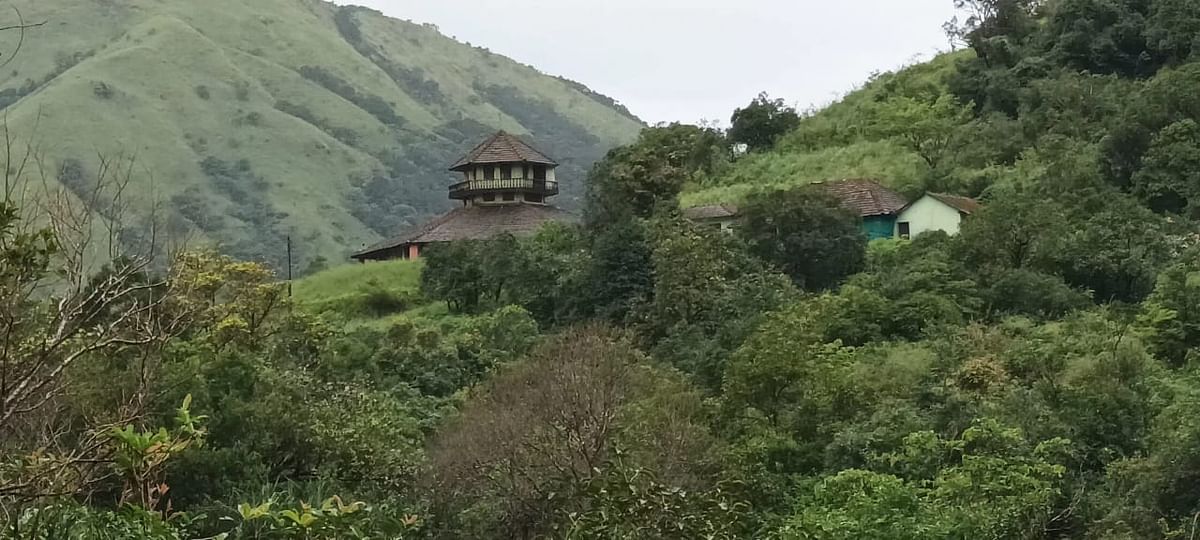 ಹಸಿರ ಬೆಟ್ಟದ ನಡುವೆ ಮಸುಕಾಗಿ ಕಾಣುತ್ತಿರುವ ದೃಶ್ಯ