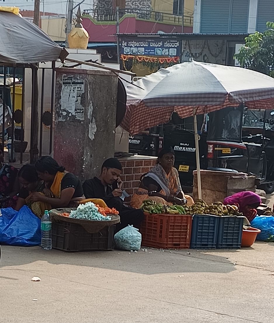 ಬಸ್ ನಿಲ್ದಾಣದ ಒಳಗಡೆ ಪ್ರವೇಶ ದ್ವಾರದ ಬಳಿ ಹಣ್ಣು ಹೂಗಳನ್ನು ಮಾರುತ್ತಿರುವ ವ್ಯಾಪಾರಸ್ಥರು