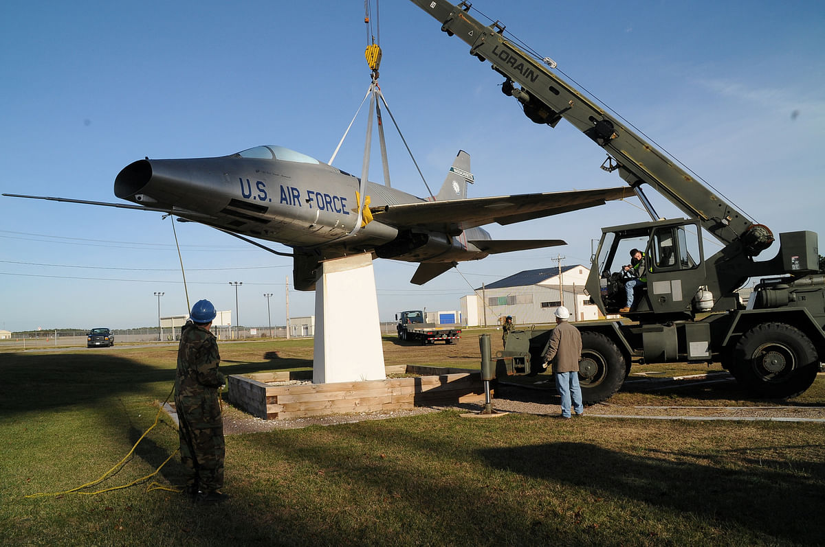 An exhibit specialist in aircraft restoration assists the 102nd Intelligence Wing Civil Engineers with the removal of an F-100 static aircraft at Otis Air National Guard Base in Cape Cod, Massachusetts, U.S. November 30, 2010.  Master Sgt. Sandra Niedzwiecki/U.S. Air Force/Handout via REUTERS THIS IMAGE HAS BEEN SUPPLIED BY A THIRD PARTY.