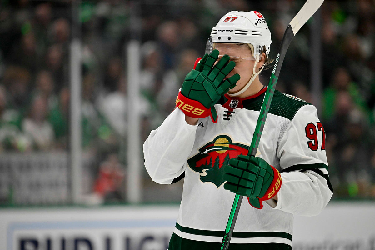 Apr 19, 2023; Dallas, Texas, USA; Minnesota Wild left wing Kirill Kaprizov  adjusts his helmet before a face-off against the Dallas Stars during the third period in game two of the first round of the 2023 Stanley Cup Playoffs at American Airlines Center. Mandatory Credit: Jerome Miron-USA TODAY Sports