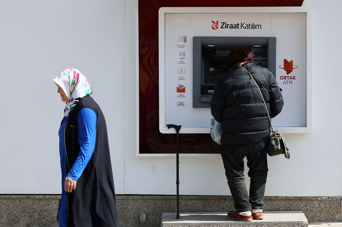 A person withdraws money from an ATM machine, following the results of the second round of the presidential election in Ankara, Turkey May 29, 2023. REUTERS/Yves Herman