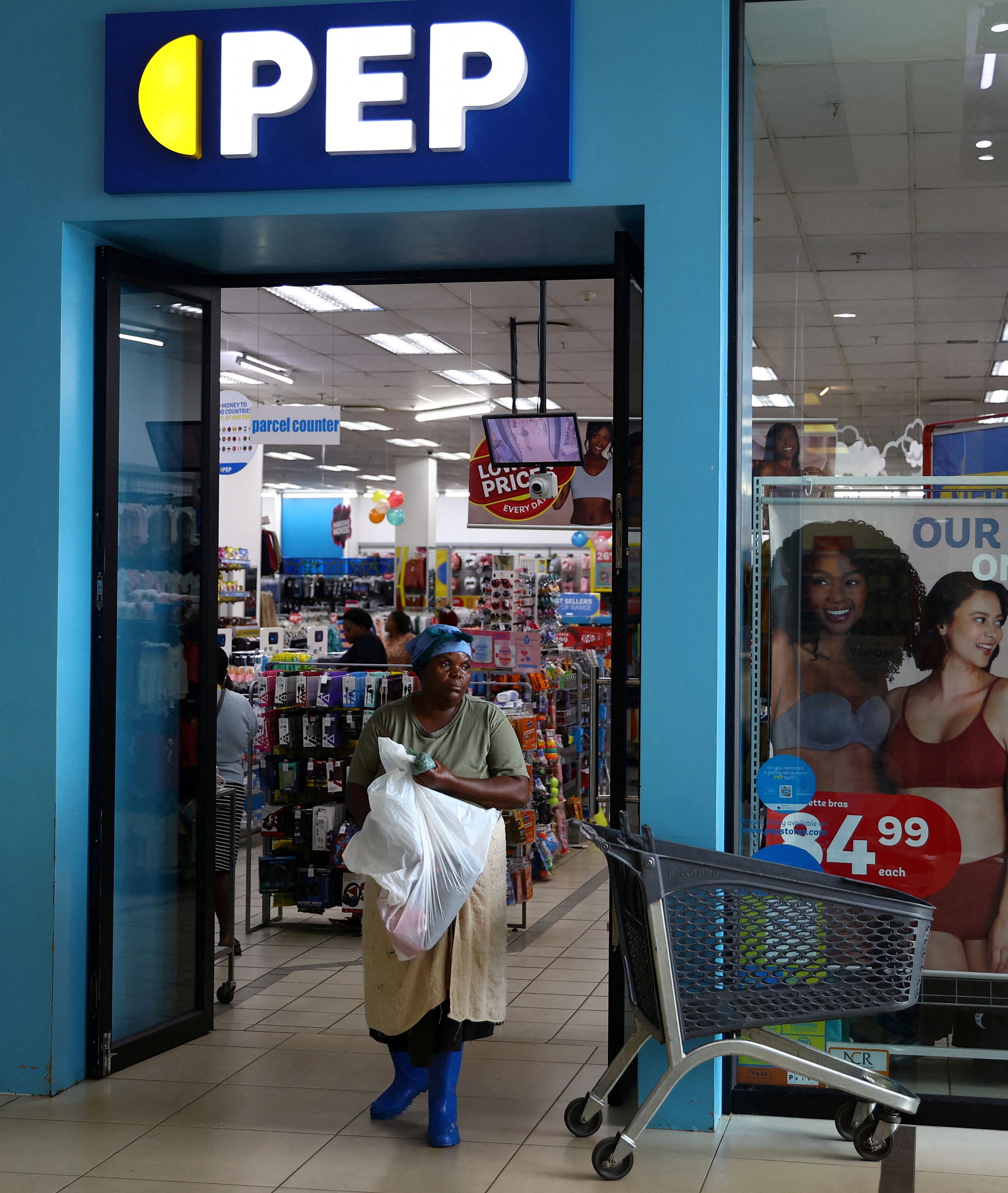 FILE PHOTO: A shopper walks out of discount retailer PEP store at the Trade Route Mall, in Lenasia outside Johannesburg, South Africa, February 8, 2023. REUTERS/Siphiwe Sibeko/File Photo