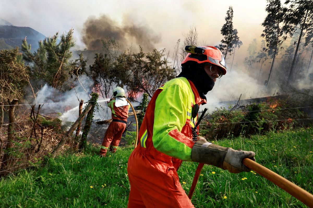 Firefighters tackle a blaze near the village of Setienes during an outbreak of wildfires in northern Spain's Asturias region, March 31, 2023. REUTERS/Vincent West *** Local Caption ***