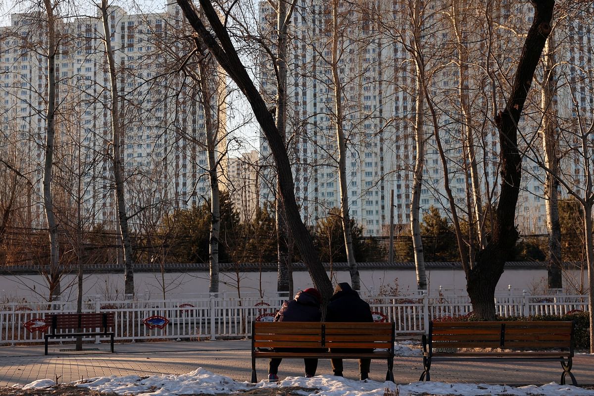 FILE PHOTO: People sit on a bench at a park near residential buildings in Beijing, China January 15, 2024. REUTERS/Florence Lo/File Photo