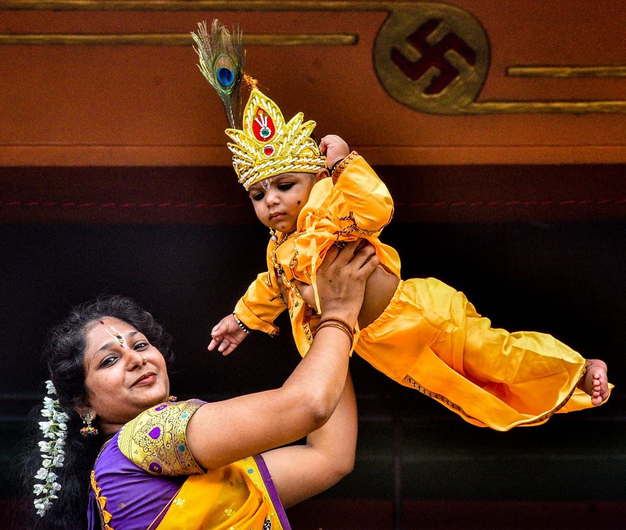 ಕೃಷ್ಣ ವೇಷಧಾರಿ ಮಗುವನ್ನು ಎತ್ತಿ ಹಿಡಿದ ಅಮ್ಮ– ಪ್ರಜಾವಾಣಿ ಚಿತ್ರ/ತಾಜುದ್ದೀನ್ ಆಜಾದ್‌