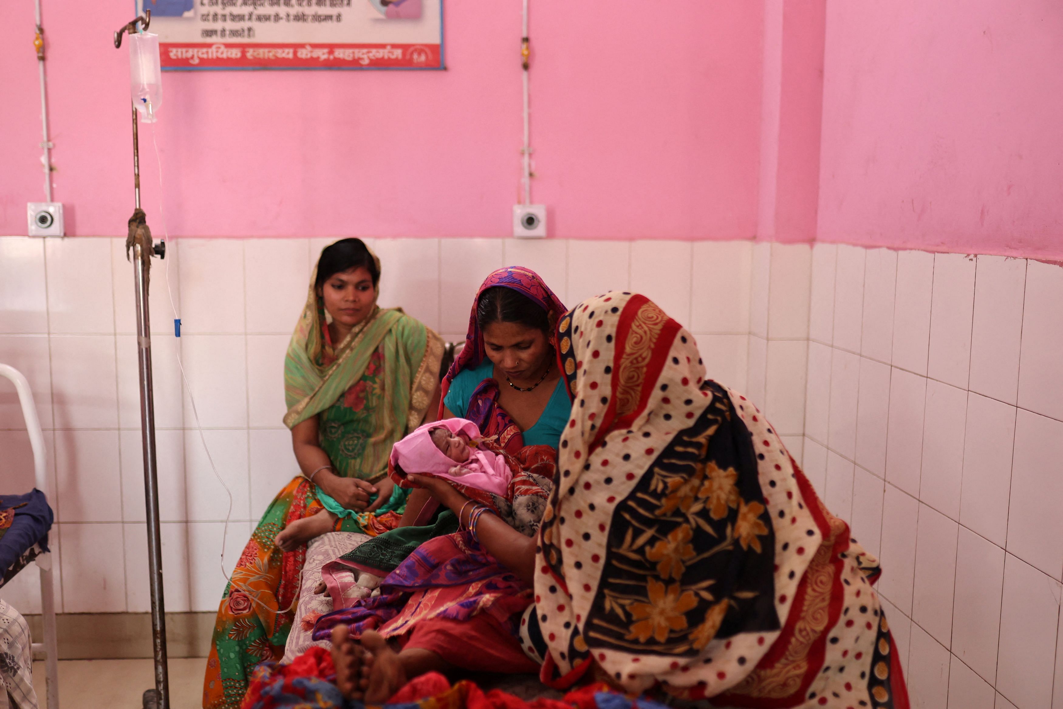 Zamerun Nisha, 33, holds her newborn baby as her sister Sanerum, 38, and her sister-in-law Zabinad, 1