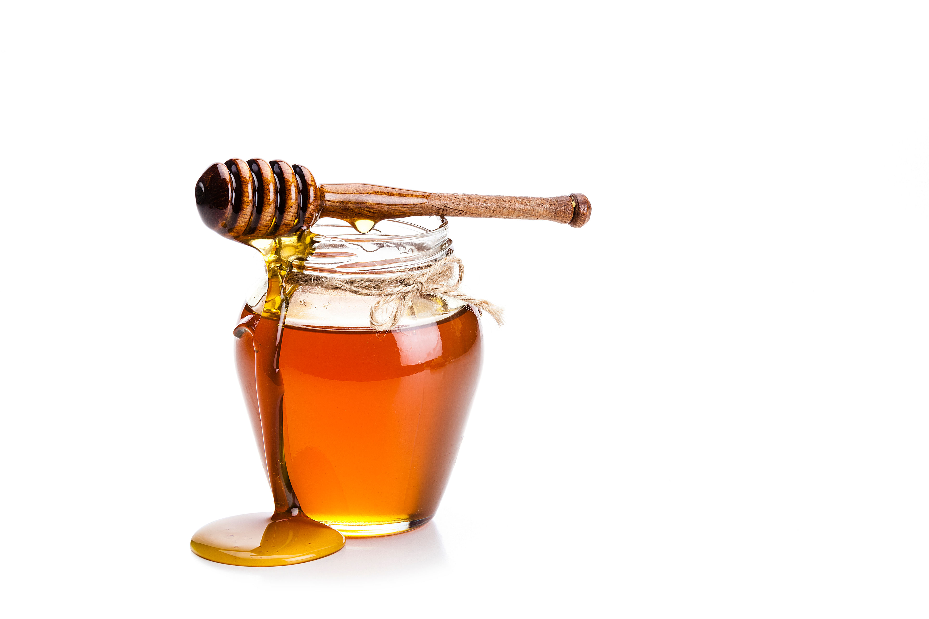 <div class="paragraphs"><p>Open honey jar with a honey dipper dripping honey on the jar and table. The composition is isolated on white background at the left of an horizontal frame.</p></div>