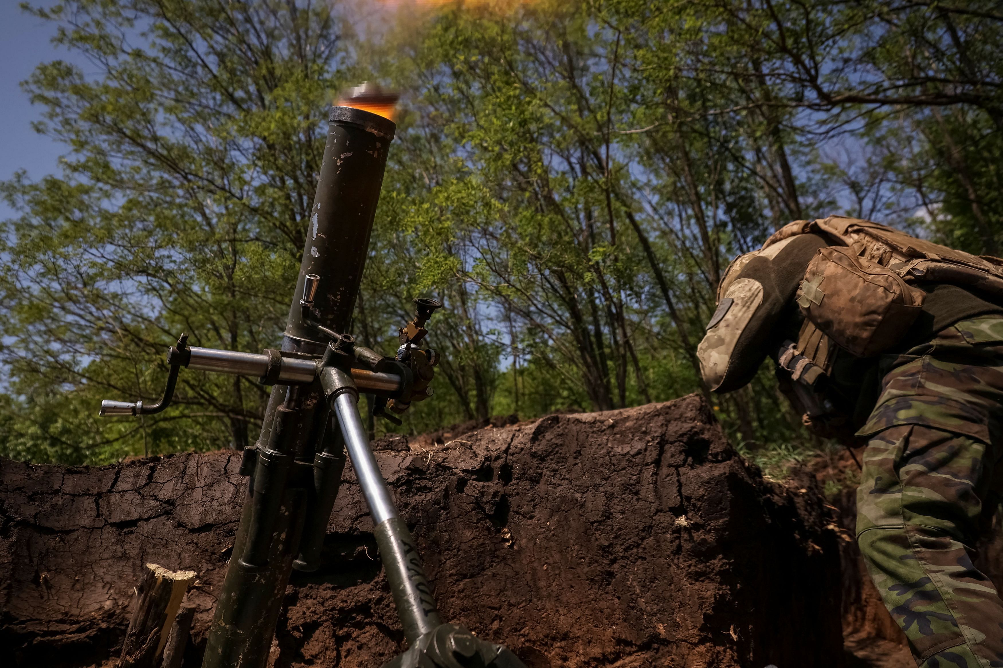 A Ukrainian service member from a 28th separate mechanised brigade named after the Knights of the Winter Campaign of the Armed Forces of Ukraine, fires a mortar at his position at a front line, amid Russia's attack on Ukraine, near the city of Bakhmut in Donetsk region, Ukraine May 18, 2023. REUTERS/Sofiia Gatilova