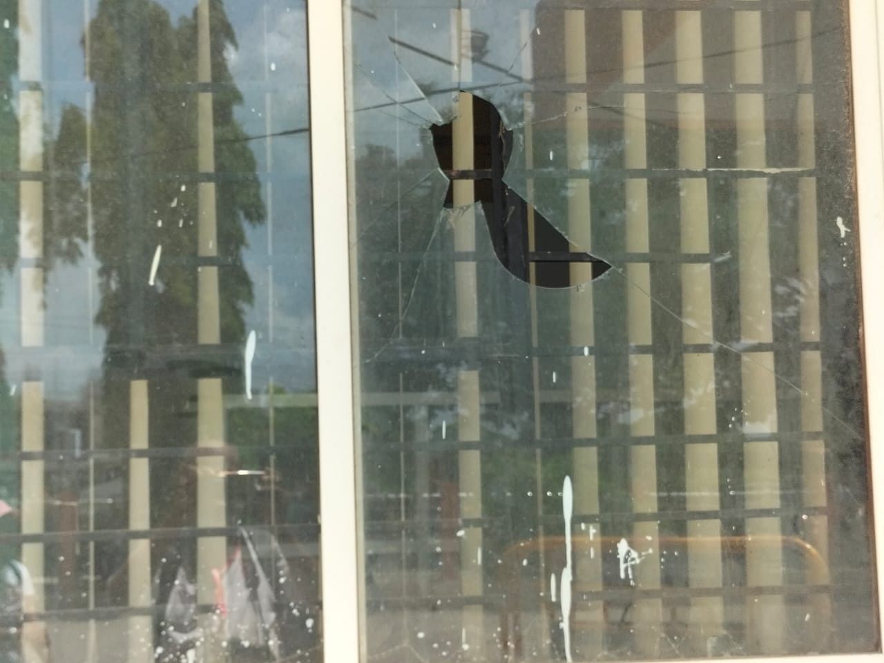 A window glass pane of Mescom office was damaged after some BJP workers threw stones at the office during the protest held against power tariff hike in Shivamogga on Wednesday. DH Photo