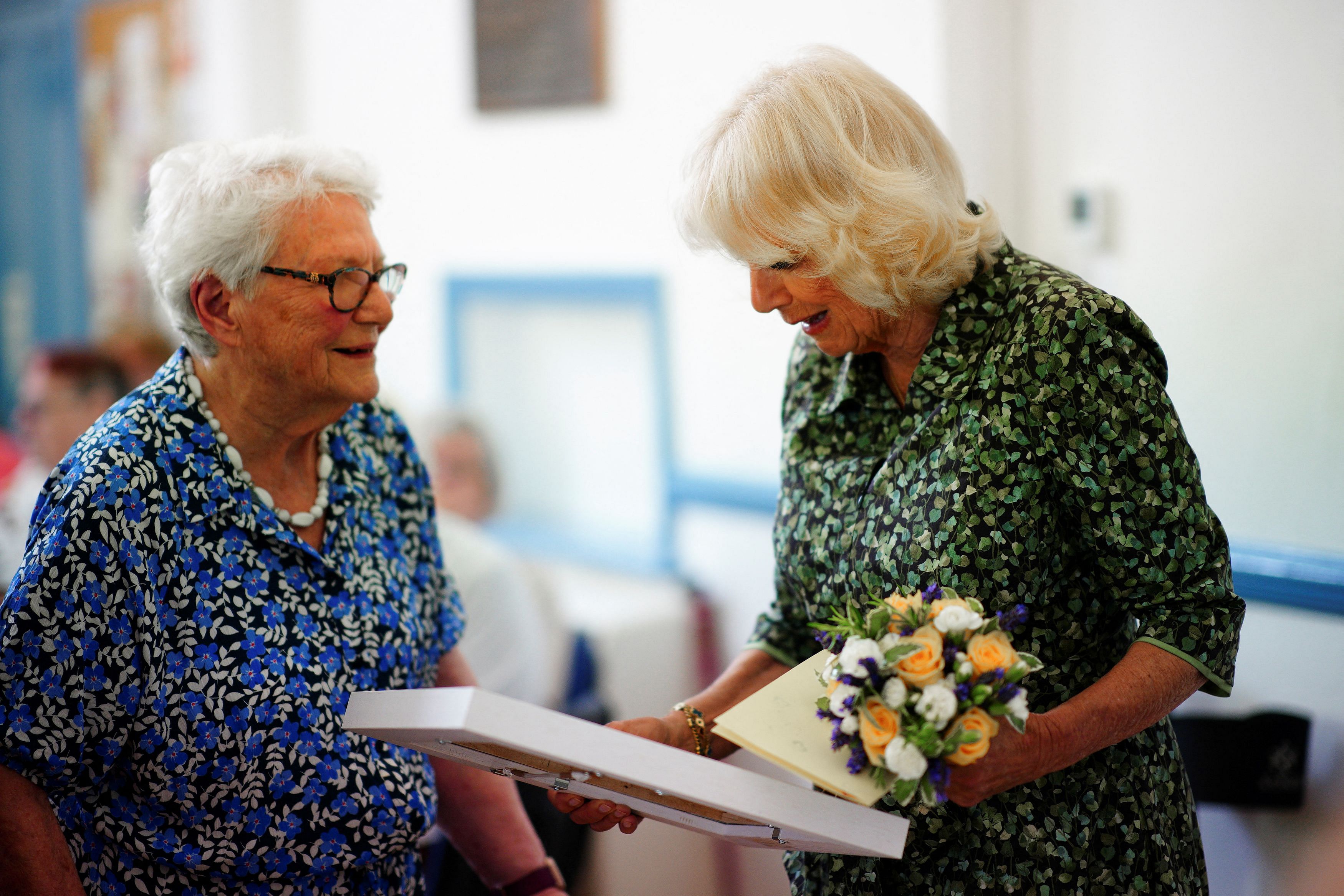 <div class="paragraphs"><p>Queen Camilla receives a painting from Jill Biddick, during a visit to the Oasis Centre at the Columba Centre in St Columb Major, Cornwall.</p></div>