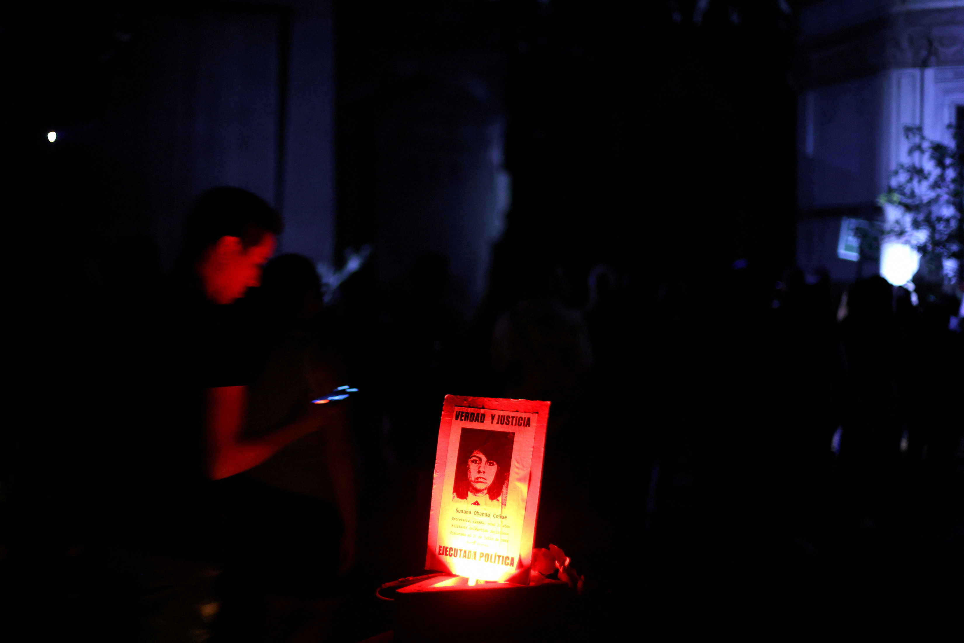 FILE PHOTO: Local residents walk past a banner reading "True and Justice" while actors perform "Voces de los Patios" , a theatrical performance through the stories of witnesses and victims of the political violence during the dictatorship, ahead of the 50th anniversary of the coup d'etat in Chile that ushered in a 17-year dictatorship under the Pinochet regime, at Santiago's General Cemetery, Chile, April 2, 2023. REUTERS/Ivan Alvarado/File Photo