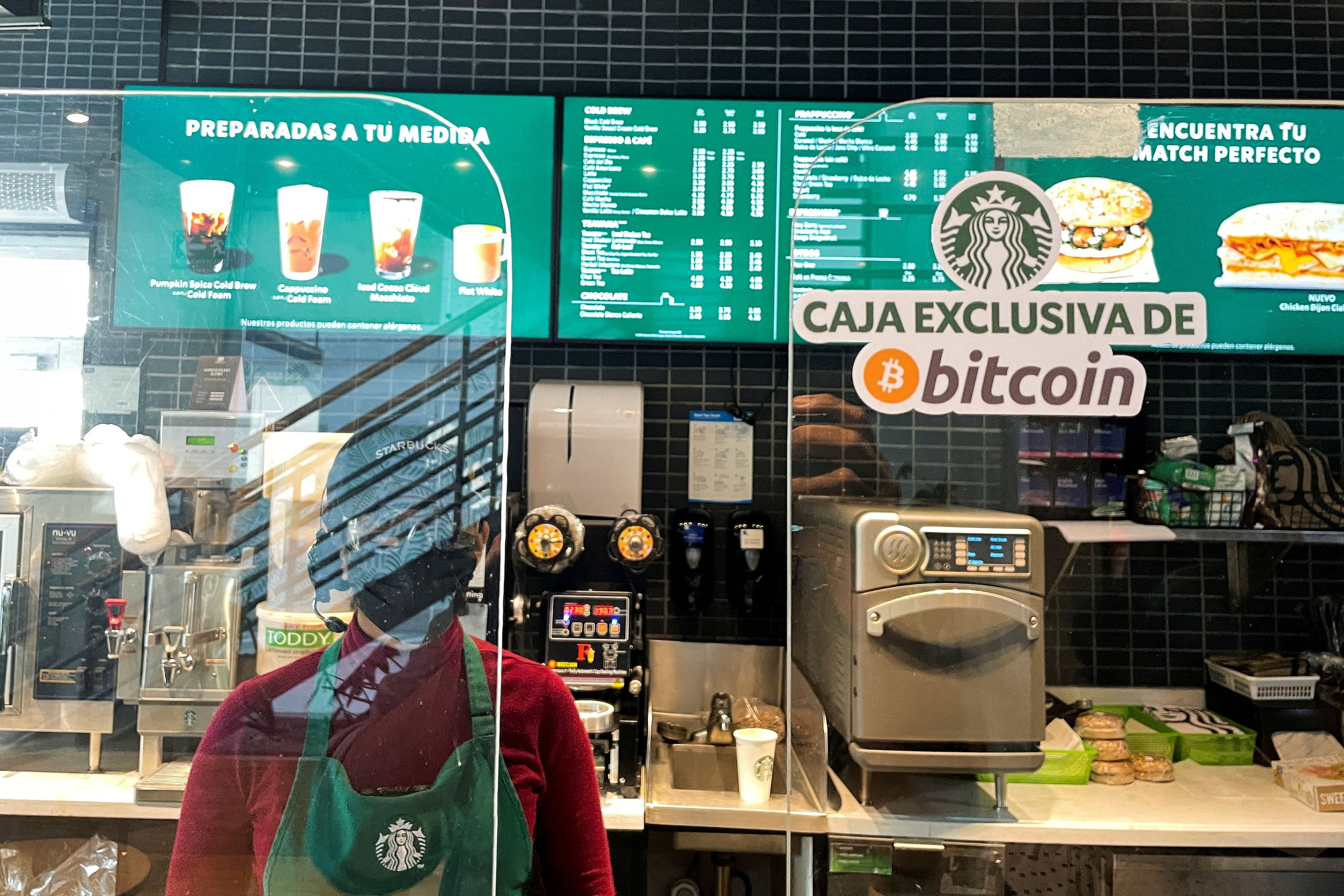 FILE PHOTO: A sign reads: "Exclusive Bitcoin register" in a Starbucks store where the cryptocurrency is accepted as a payment method, in San Salvador, El Salvador September 7, 2021. REUTERS/Jose Cabezas/File Photo