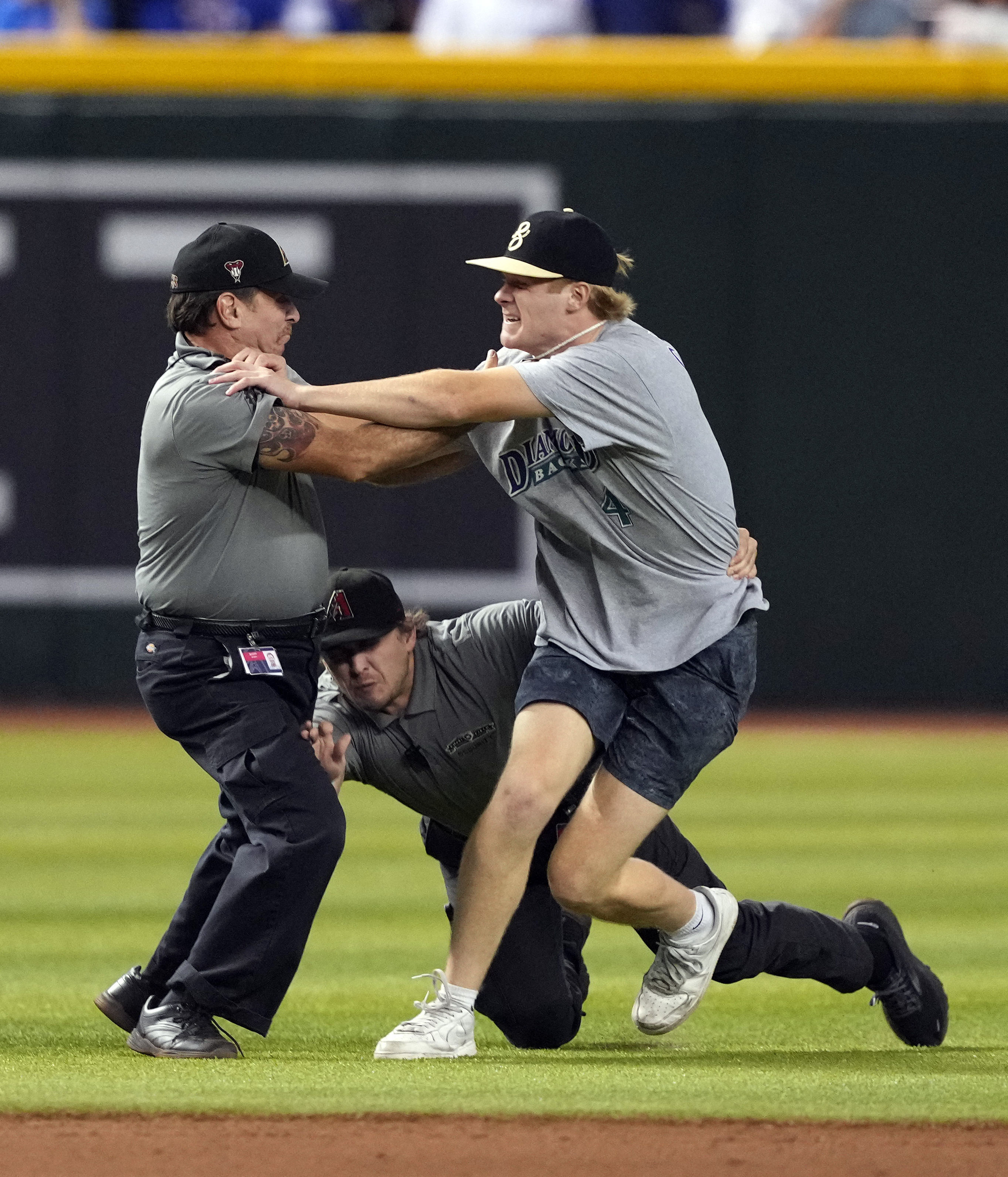 Sep 16, 2023; Phoenix, Arizona, USA; Security runs down a fan who ran onto the field during the 12th inning of the game between the Arizona Diamondbacks and the Chicago Cubs at Chase Field. Mandatory Credit: Joe Camporeale-USA TODAY Sports