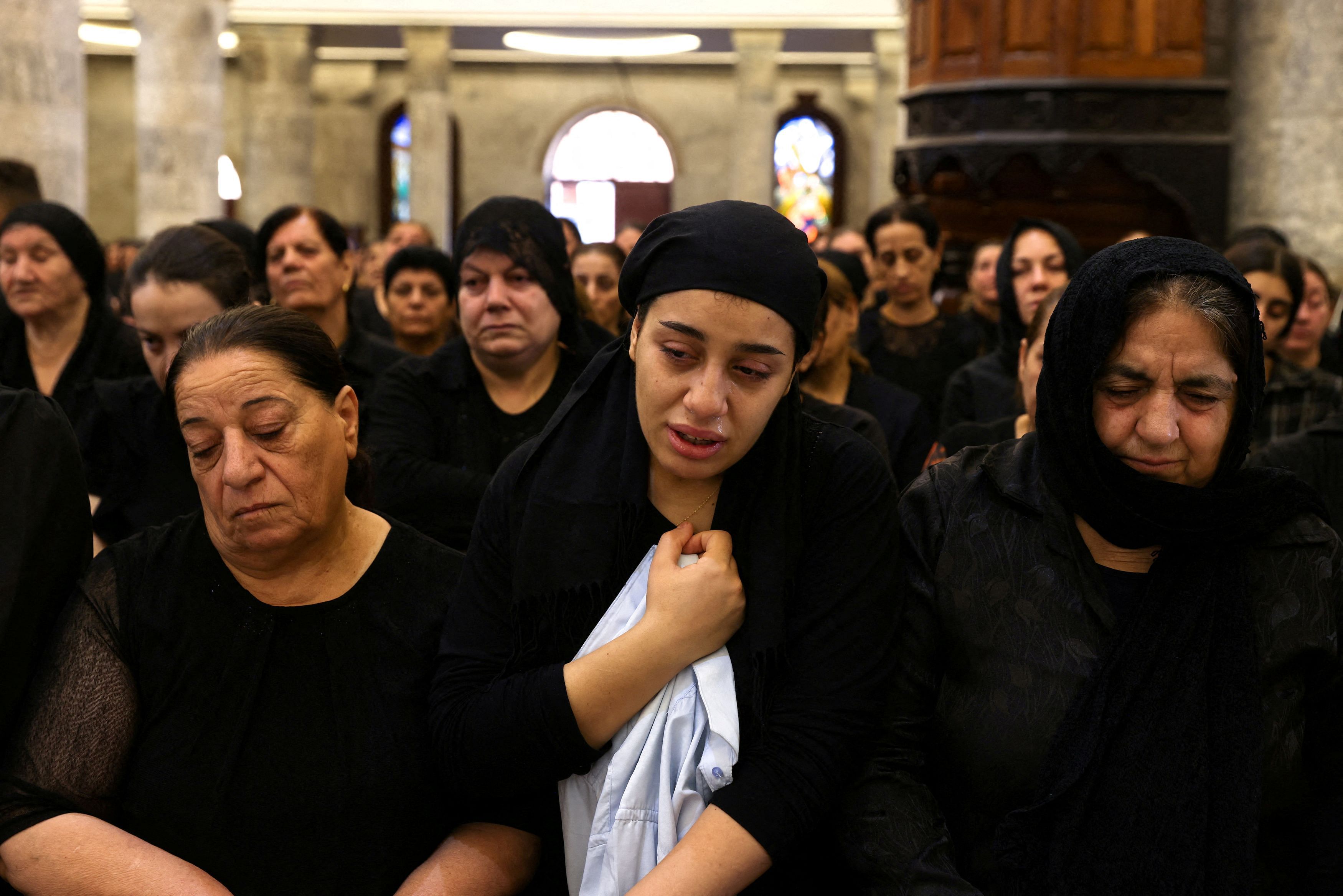 <div class="paragraphs"><p>Iraqi Christians react as they attend a mass following a fatal fire at a wedding.</p></div>