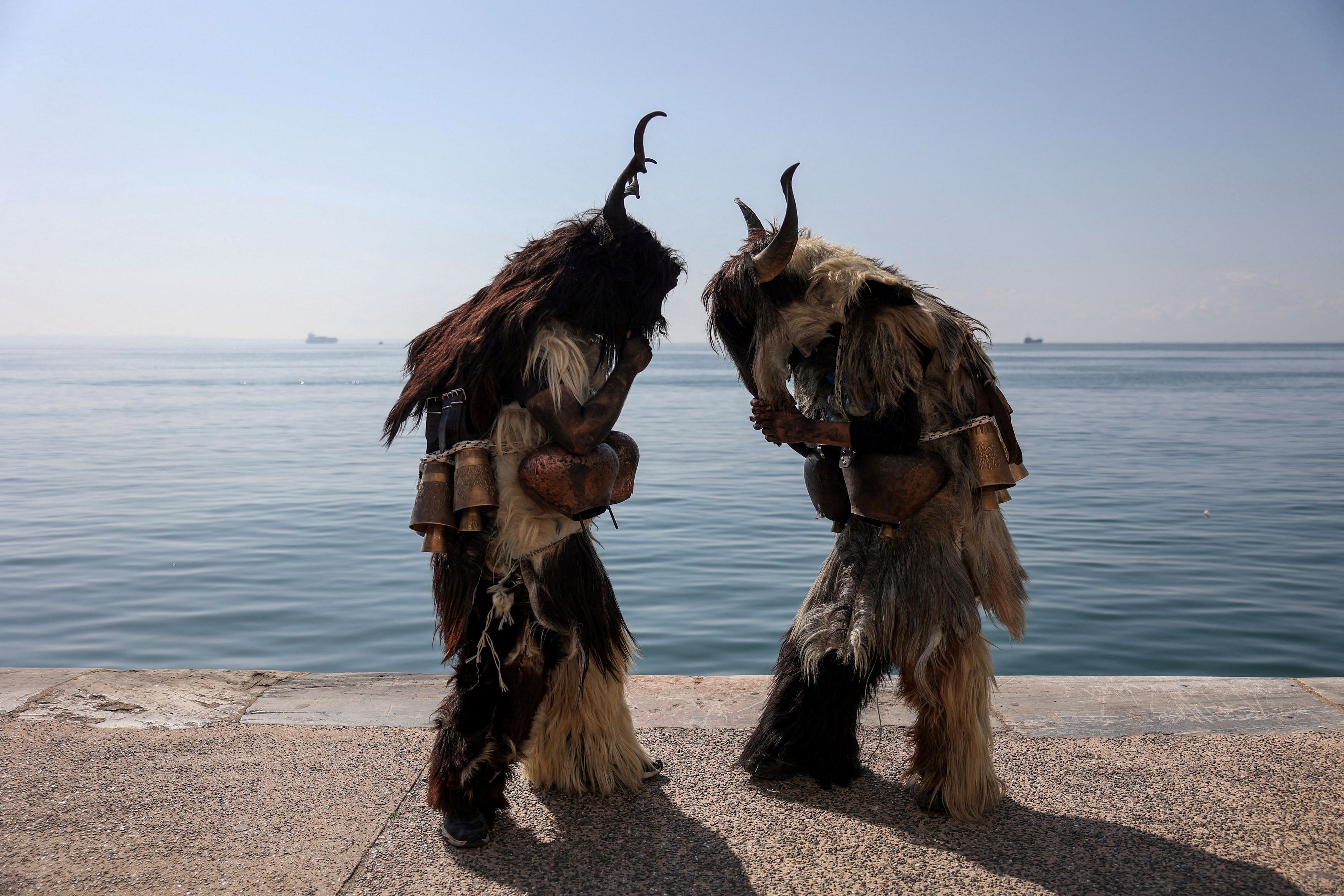 Participants stand by the seaside during the 6th European Festival of Bell-bearing traditions in Thessaloniki, Greece March 3, 2024. REUTERS/Alexandros Avramidis     TPX IMAGES OF THE DAY