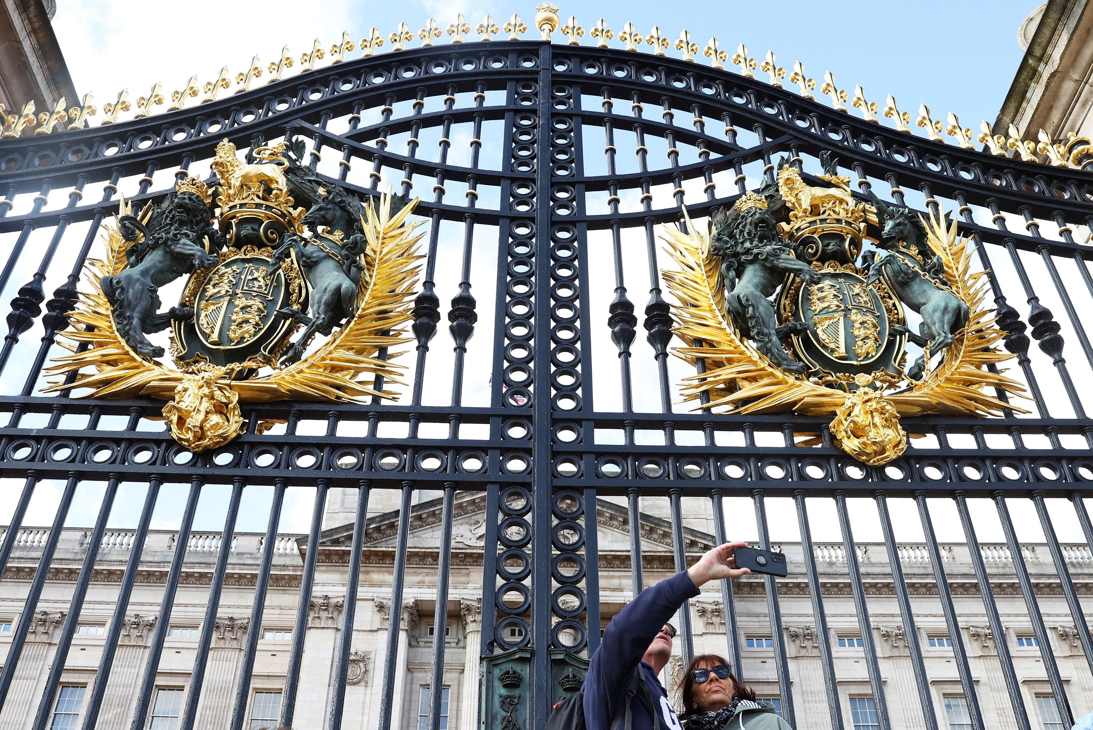 Visitors pose in front of Buckingham Palace the day after the news that Britain's Catherine, Princess of Wales has revealed she is undergoing preventative chemotherapy after tests taken following abdominal surgery in January revealed cancer had been present, in London, Britain, March 23, 2024. REUTERS/Toby Melville