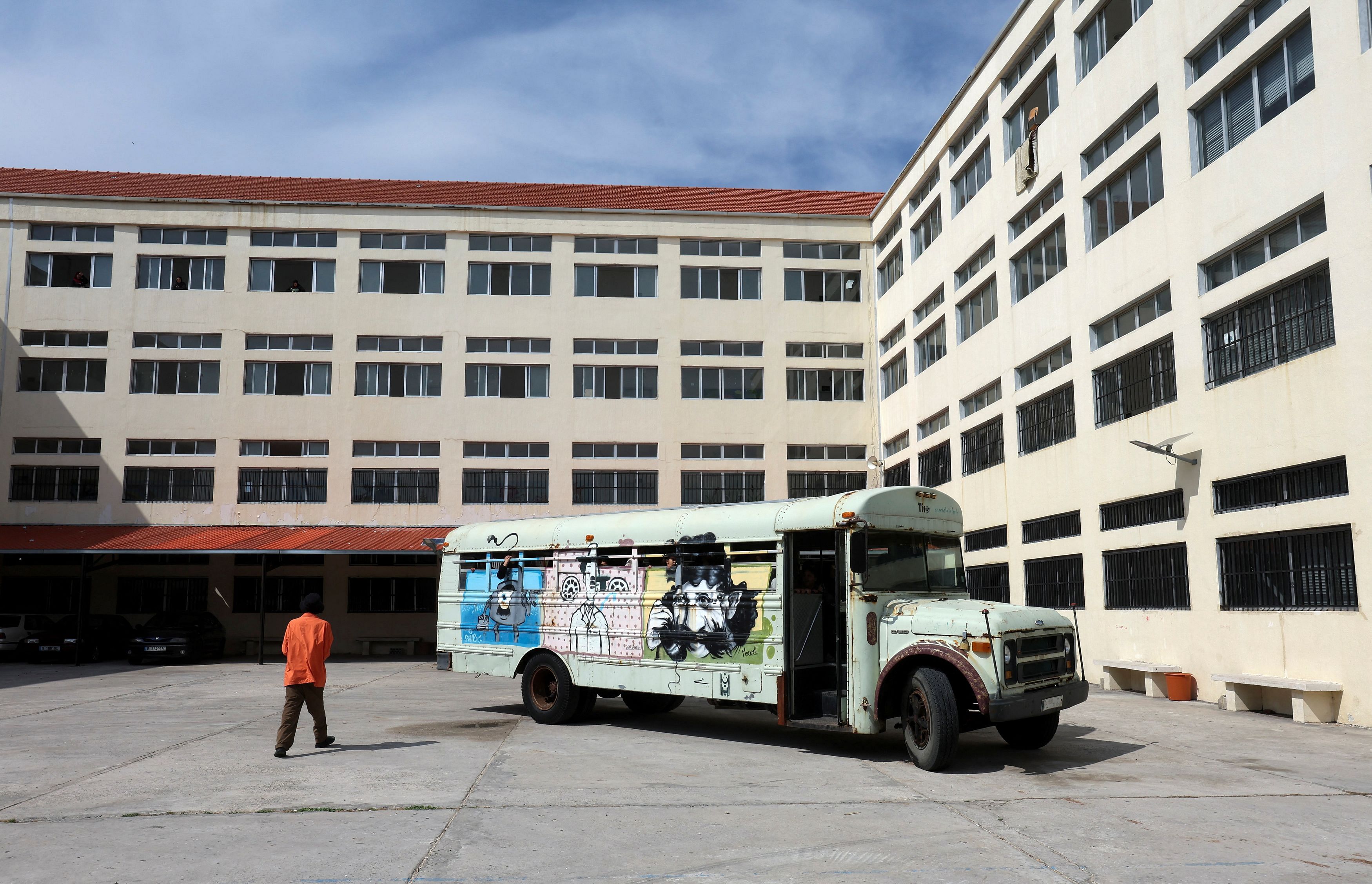 A person walks next to the 'Peace Art Bus', which transports displaced children from a school sheltering families, who fled from their border villages due to cross-border hostilities between Hezbollah and Israeli forces, to a theatre, where they will participate in entertaining activities for Eid al-Fitr, which marks the end of the Muslim holy fasting month of Ramadan, in Tyre, southern Lebanon April 9, 2024. REUTERS/Aziz Taher