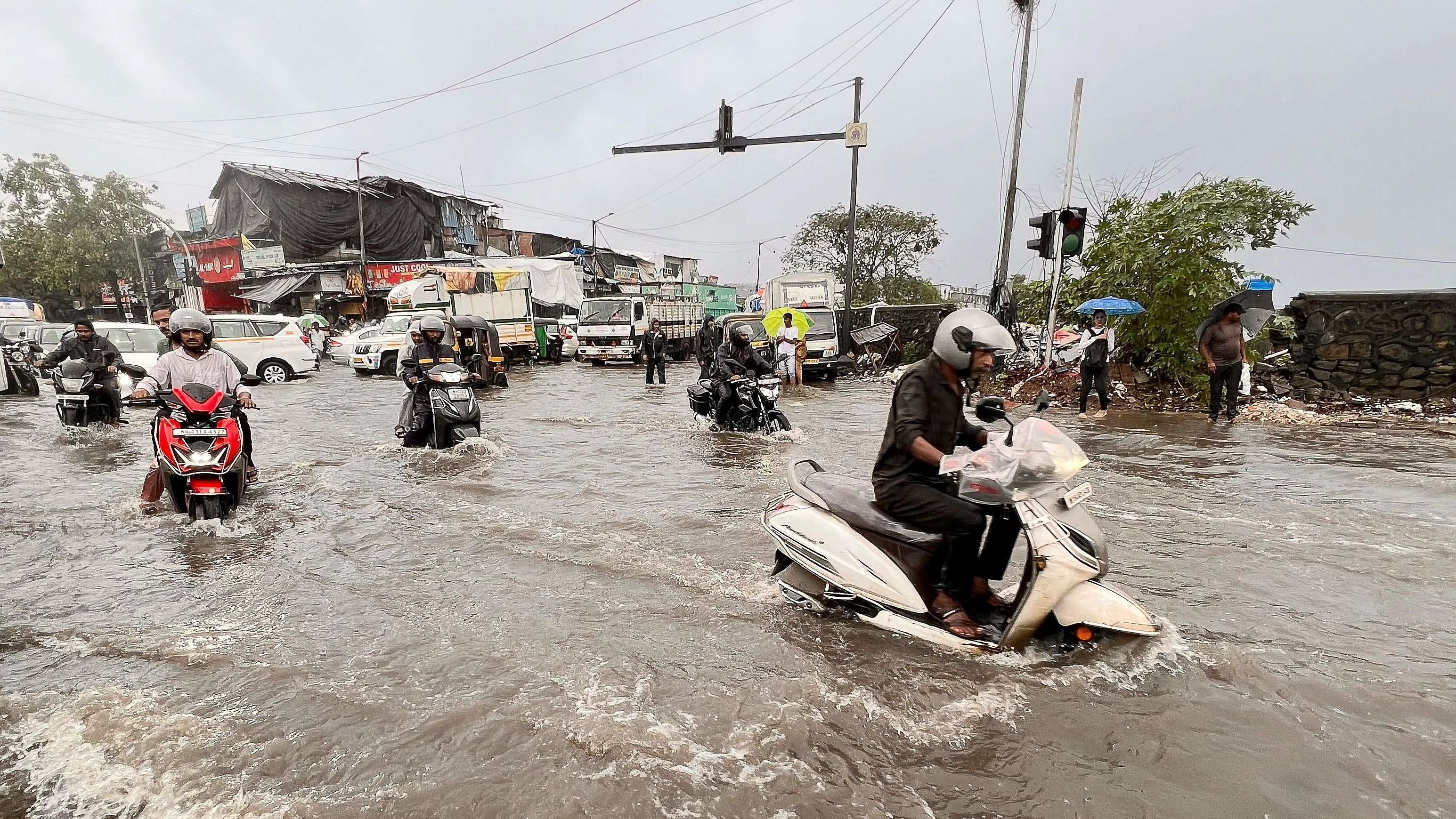 ಮುಂಬೈ ಮಹಾನಗರದಲ್ಲಿ ಸುರಿಯುತ್ತಿರುವ ಮುಂಗಾರು ಮಳೆಗೆ ರಸ್ತೆಗಳೆಲ್ಲವೂ ಹೊಳೆಯಂತಾಗಿದ್ದು, ಶುಕ್ರವಾರ ರಸ್ತೆಯಲ್ಲಿ ಸಂಚರಿಸಲು ಮೋಟರ್‌ ಬೈಕ್‌ ಸವಾರರು ಪರದಾಡಿದರು– ಎಎಫ್‌ಪಿ ಚಿತ್ರ  