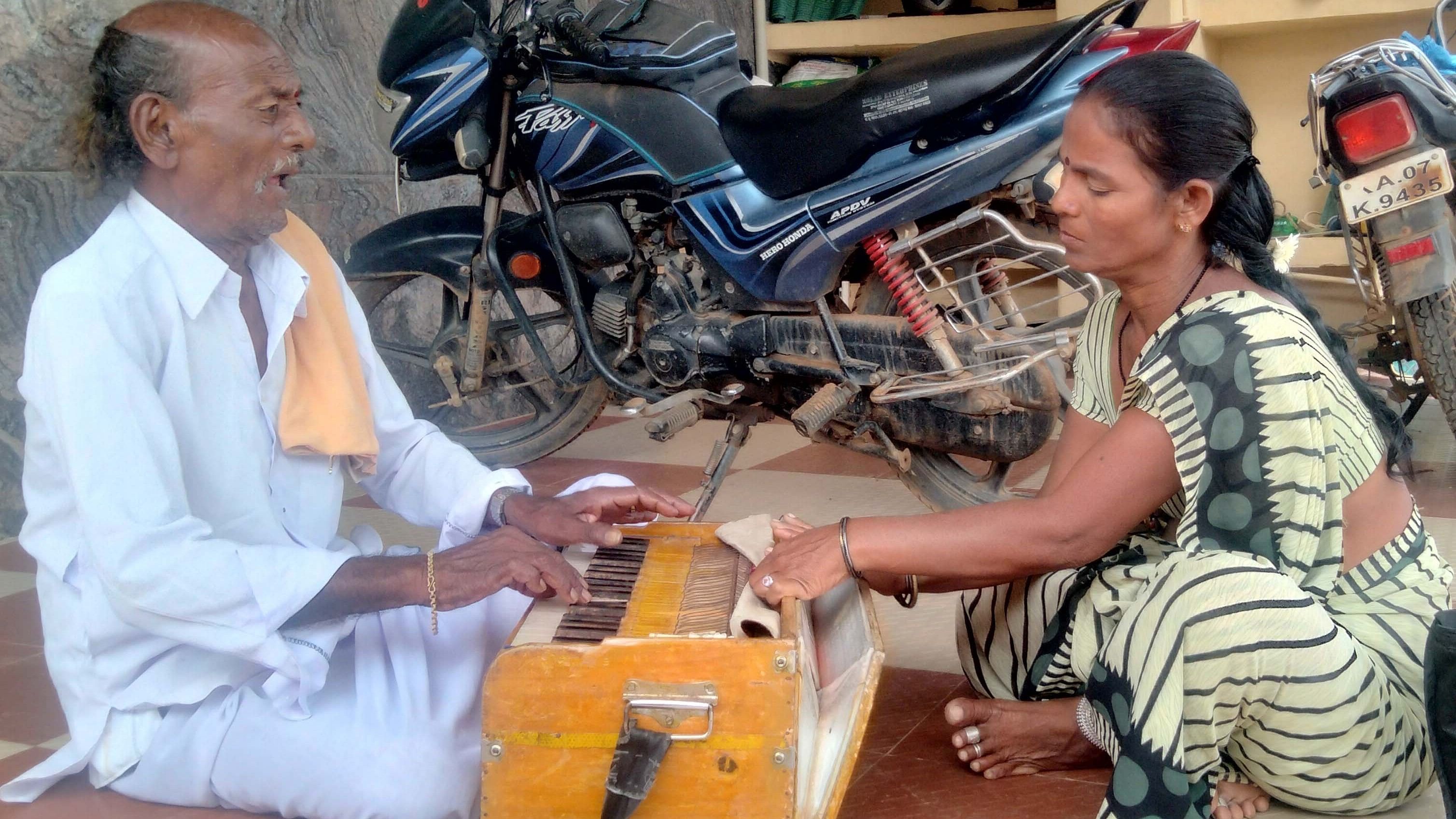 ಶ್ರೀನಿವಾಸಪುರ ತಾಲ್ಲೂಕಿನ ಪನಸಮಾಕನಹಳ್ಳಿ ಗ್ರಾಮದ ಮನೆಯೊಂದರ ಮುಂದೆ ಮಗಳೊಂದಿಗೆ ಹಾರ್ಮೋನಿಯಂ ನುಡಿಸುತ್ತ ಹಾಡುತ್ತಿರುವ ತೊಗಲು ಗೊಂಬೆ ಕಲಾವಿದ ಸತ್ಯನಾರಾಯಣ