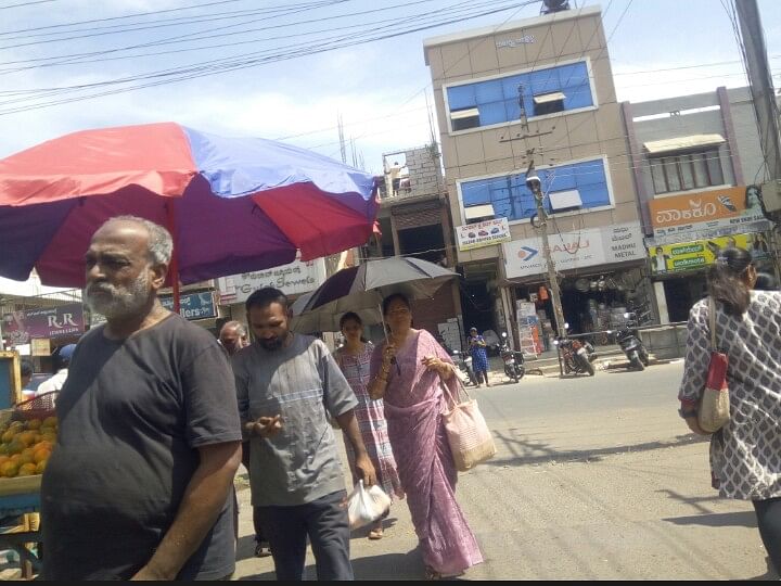 ಬಿ.ಹೆಚ್.ರಸ್ತೆಯ ಮಾರುಕಟ್ಟೆಯಲ್ಲಿ ಬಿಸಿಲಿನ ತಾಪದಿಂದ ಪಾರಾಗಲು ದೊಡ್ಡ ಛತ್ರಿಗಳನ್ನು ಹಾಕಿರುವುದು 