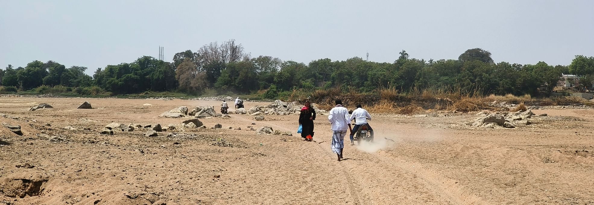 ತೆಕ್ಕಲಕೋಟೆ ಸಮೀಪದ ನಿಟ್ಟೂರು ಬಳಿ ಬತ್ತಿದ ತುಂಗಭದ್ರಾ ನದಿಯಲ್ಲಿ ಬೈಕ್ ಸವಾರರು ಸಾಗುತ್ತಿರುವುದು