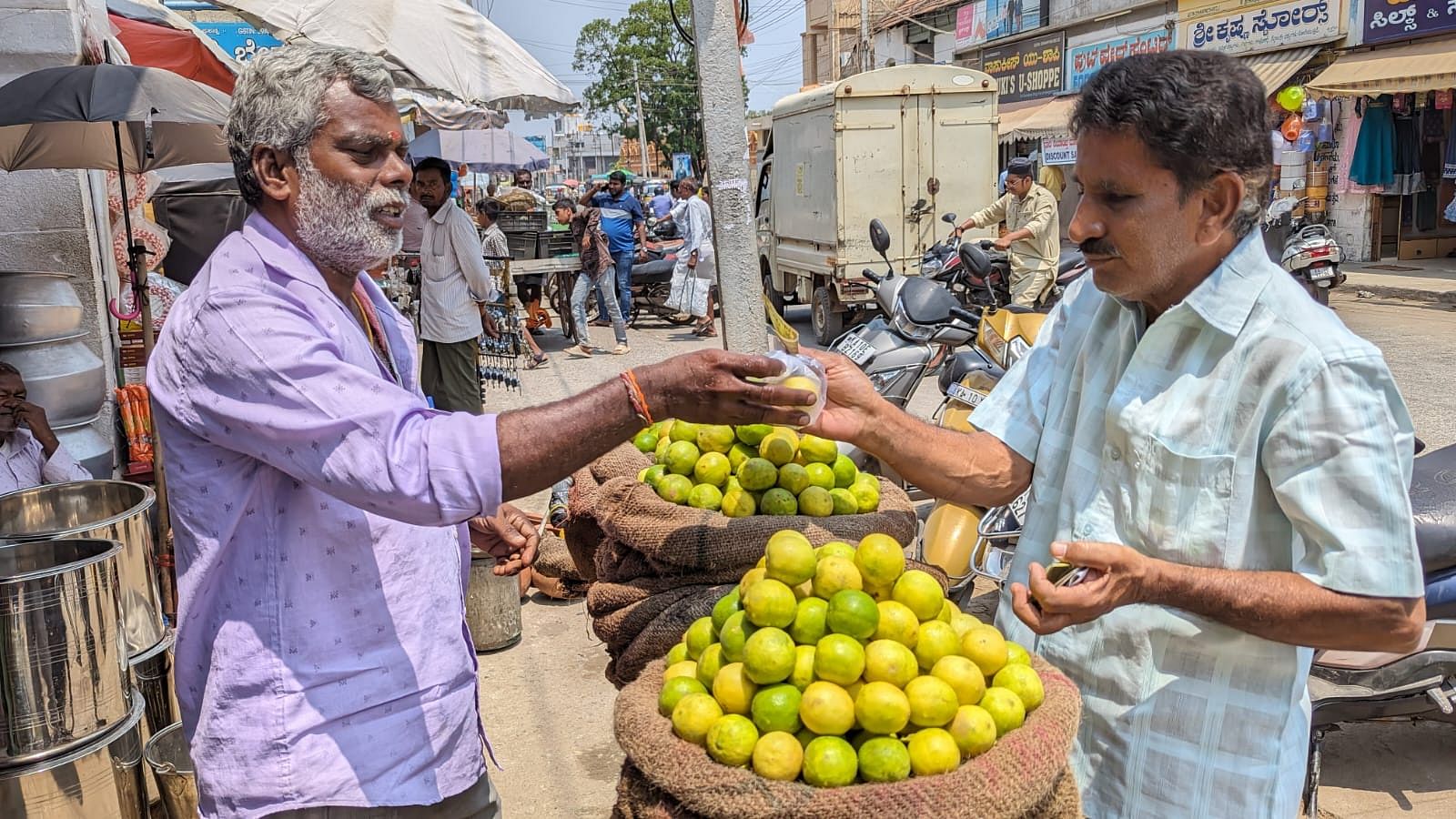 ಚಾಮರಾಜನಗರದ ದೊಡ್ಡಂಗಡಿ ಬೀದಿಯಲ್ಲಿ ವ್ಯಾಪಾರಿ ಸಿದ್ದರಾಜು ಅವರ ಬಳಿ ಗ್ರಾಹಕರೊಬ್ಬರು ನಿಂಬೆ ಹಣ್ಣು ಖರೀದಿಸಿದರು