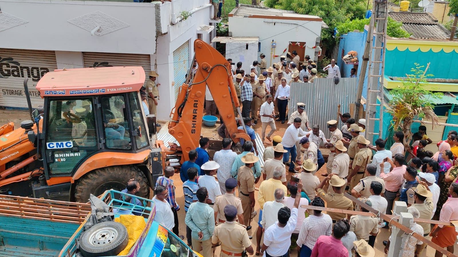 ನಗರಸಭೆಯ ಅಧಿಕಾರಿಗಳು ಪೊಲೀಸರ ಸಹಕಾರ ಪಡೆದು ಅನಧಿಕೃತವಾಗಿ ರಸ್ತೆಯಲ್ಲಿ ನಿರ್ಮಿಸಿದ್ದ ಮನೆಯನ್ನು ತೆರವುಗೊಳಿಸುವ ಸಂದರ್ಭದಲ್ಲಿ ಹೆಚ್ಚಿನ ಸಂಖ್ಯೆಯಲ್ಲಿ ಜನರು ಸೇರಿದ್ದರು