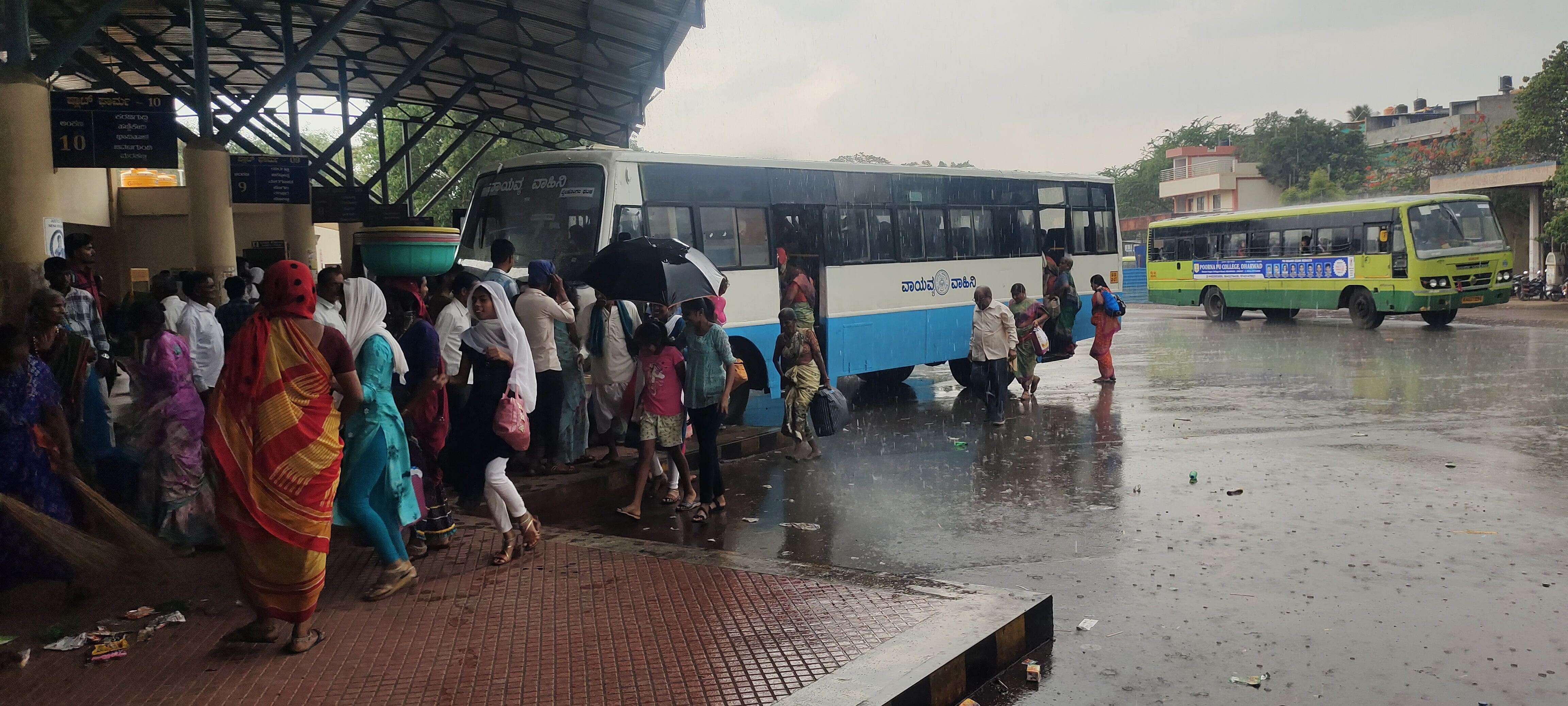 ಬೈಲಹೊಂಗಲ ಕೇಂದ್ರ ಬಸ್ ನಿಲ್ದಾಣ ಆವರಣದಲ್ಲಿ ಪ್ರಯಾಣಿಕರು ಮಳೆಯಲ್ಲೇಓಡಿ ಹೋಗಿ ಬಸ್‌ ಹತ್ತಿದರು