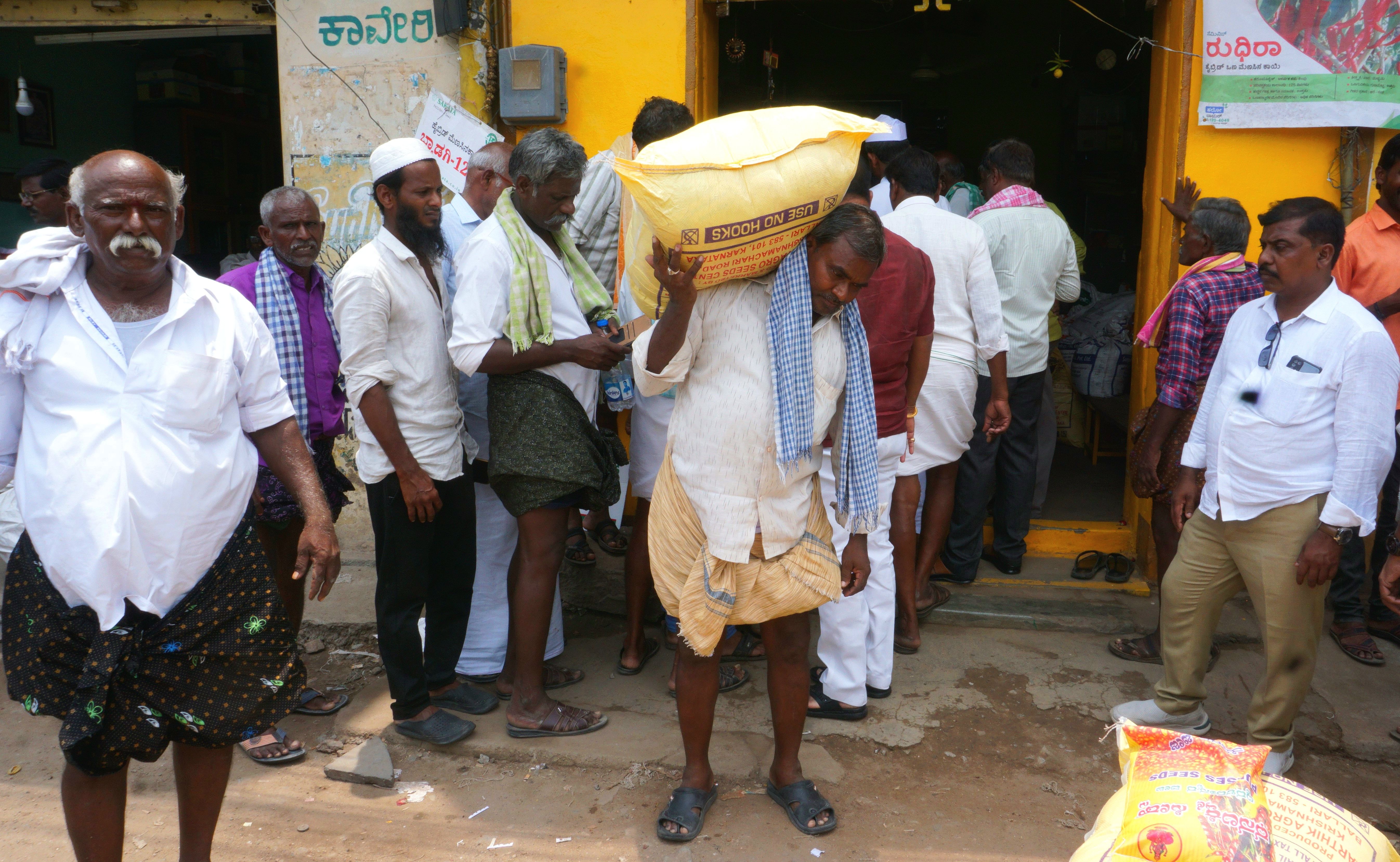 ಬಳ್ಳಾರಿಯ ಅಂಗಡಿಯೊಂದರಲ್ಲಿ ಬಿತ್ತನೆ ಬೀಜ ಖರೀದಿಸಿ ಕೊಂಡೊಯ್ಯುತ್ತಿರುವ ರೈತರು