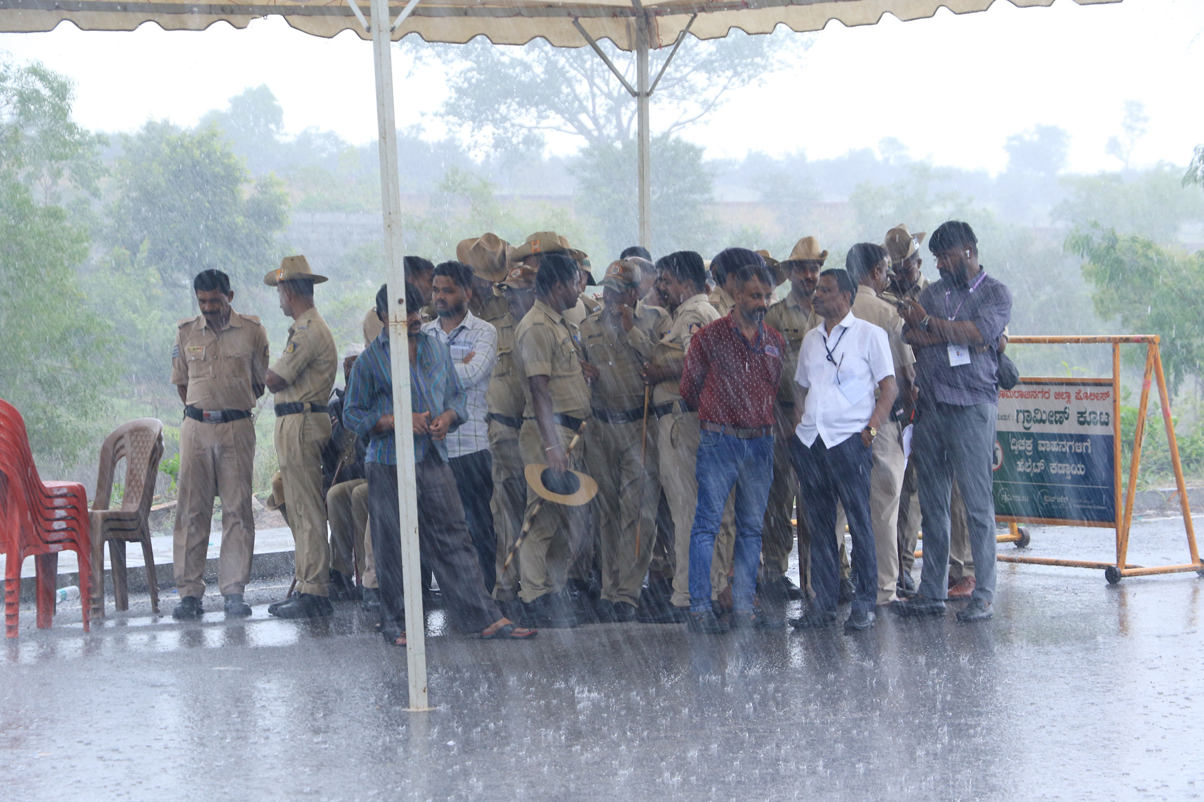 ಬೇಡರಪುರದಲ್ಲಿ ಮತ ಎಣಿಕೆಗೆ ಕಾರ್ಯಕ್ಕೆ ನಿಯೋಜನೆ ಗೊಂಡಿದ್ದ ಭದ್ರತಾ ಸಿಬ್ಬಂದಿ ಮಳೆಯಿಂದ ರಕ್ಷಿಸಿಕೊಳ್ಳಲು ತಾತ್ಕಾಲಿಕ ಡೇರೆಯ ಆಶ್ರಯ ಪಡೆದರು