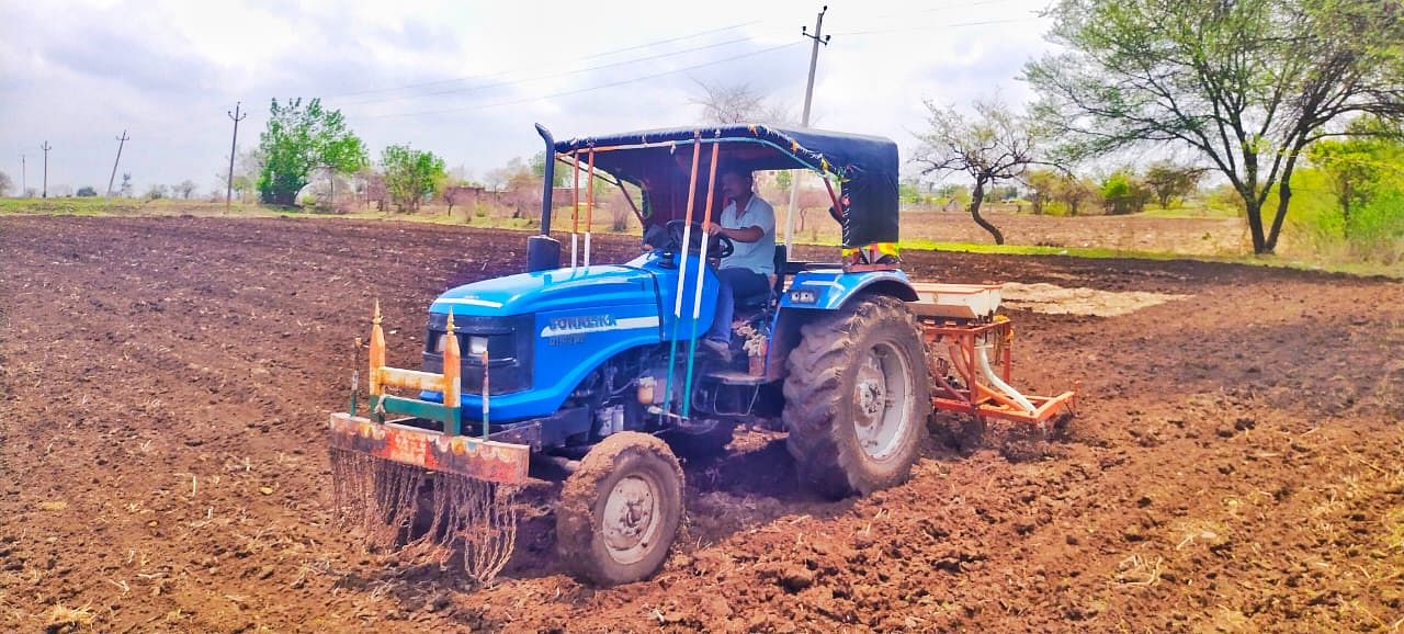 ಹುಲಸೂರಿನ ಬಳಿ ಜಮೀನಿನಲ್ಲಿ ರೈತರೊಬ್ಬರು ಟ್ರ್ಯಾಕ್ಟರ್ ಬಳಸಿ ಉಳುಮೆ ಮಾಡುತ್ತಿರುವುದು