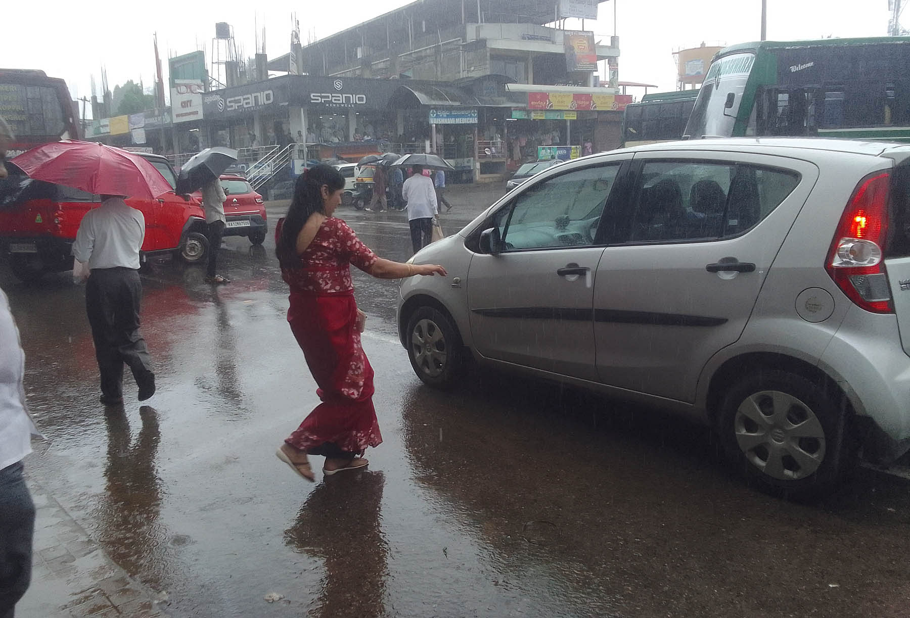 ಗೋಣಿಕೊಪ್ಪಲಿನಲ್ಲಿ ಗುರುವಾರ ಸುರಿದ ಮಳೆಗೆ ಜನರು ಕೊಡೆ ಆಶ್ರಯ ಪಡೆದರು