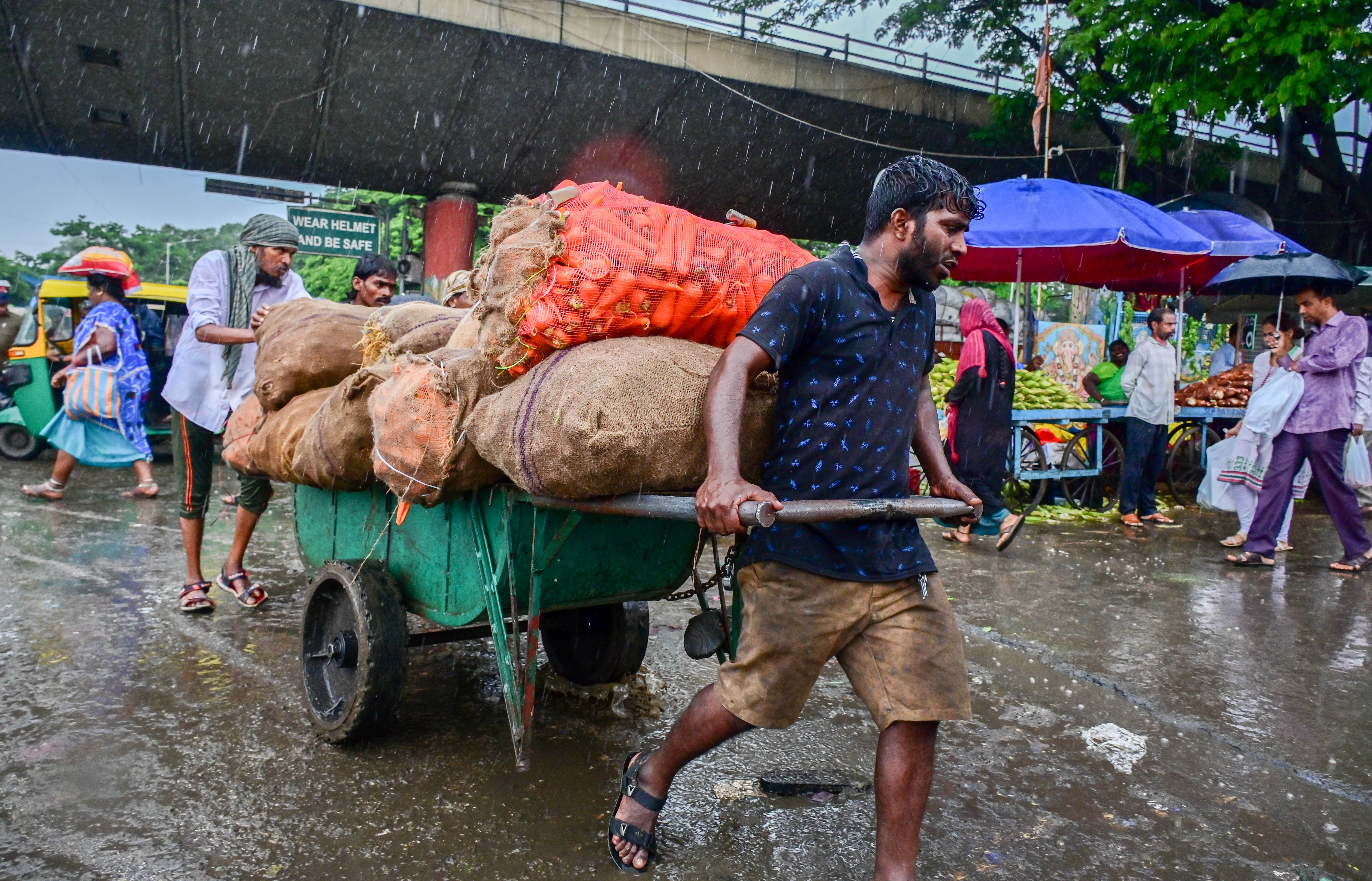 ನಗರದ ಕೆ.ಆರ್. ಮಾರುಕಟ್ಟೆಯಲ್ಲಿ ಸೋಮವಾರ ಸುರಿದ ಮಳೆಯ ನಡುವೆ ಕಾರ್ಮಿಕರೊಬ್ಬರು ತಳ್ಳುವ ಗಾಡಿಯಲ್ಲಿ ತರಕಾರಿ ತುಂಬಿಕೊಂಡು ಸಾಗಿದರು. ಪ್ರಜಾವಾಣಿ ಚಿತ್ರ/ಪ್ರಶಾಂತ್‌ ಎಚ್.ಜಿ.