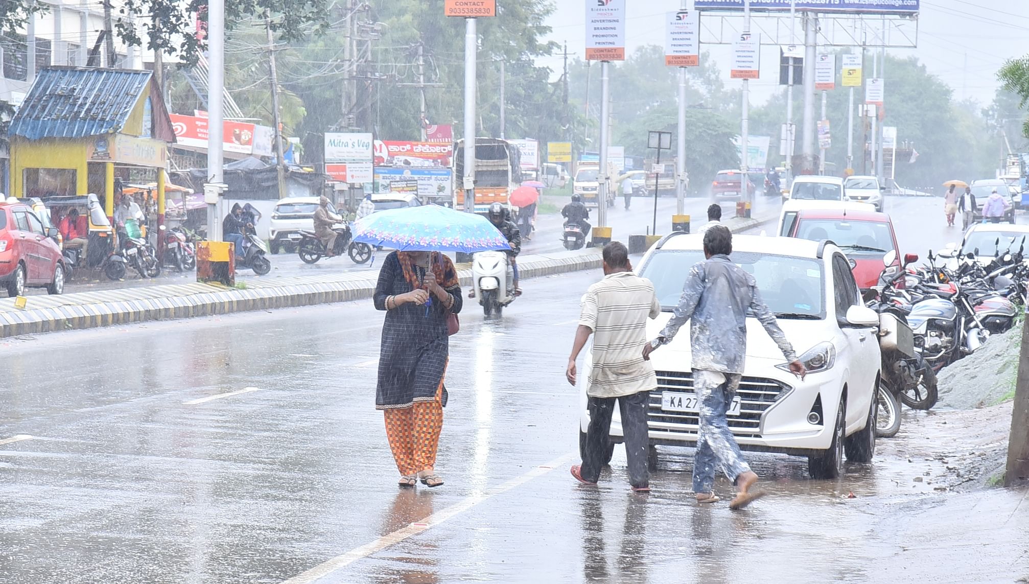 ಹಾವೇರಿ ನಗರದಲ್ಲಿ ಭಾನುವಾರ ಸುರಿಯುತ್ತಿದ್ದ ಮಳೆಯಲ್ಲಿ ಜನರು ಸಂಚರಿಸಿದರು