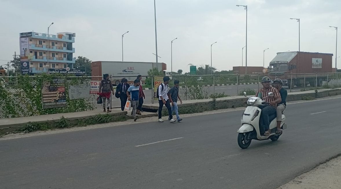 ರಾಮನಗರ ತಾಲ್ಲೂಕಿನ ಕಣಮಿಣಕಿ ಬಳಿ ಬೆಂಗಳೂರು–ಮೈಸೂರು ಹೆದ್ದಾರಿಗೆ ನಿರ್ಮಿಸಿರುವ ಬೇಲಿಯನ್ನು ಹಾದು ರಸ್ತೆ ದಾಟುವ ಸ್ಥಳೀಯರು