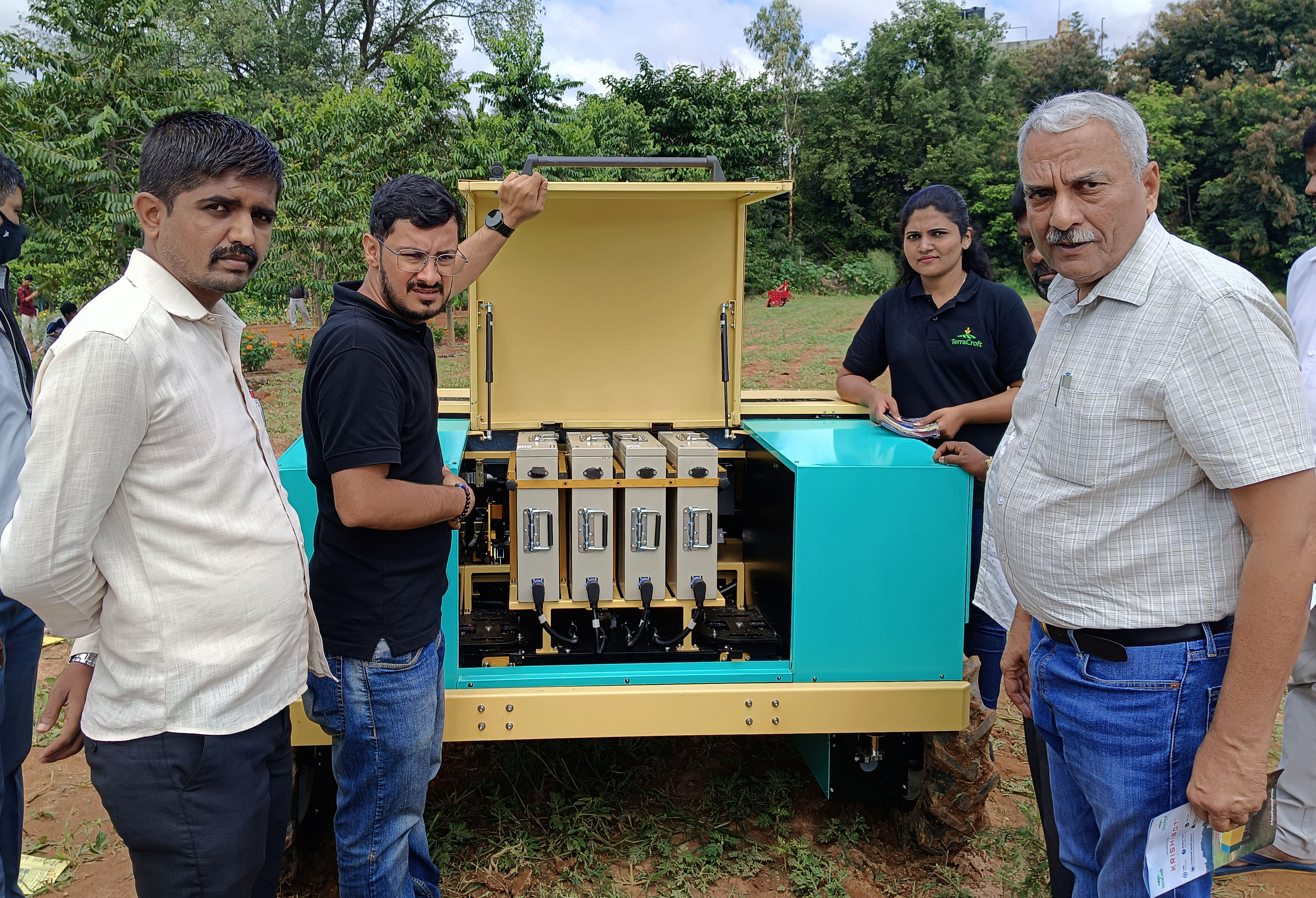 ಕೃಷಿಮೇಳದಲ್ಲಿರುವ ಕೃಷಿಬಾಟ್‌ ಯಂತ್ರದ ಬ್ಯಾಟರಿಗಳನ್ನು ಪ್ರದರ್ಶಿಸಿದ ಸಂಸ್ಥೆಯ ಪ್ರತಿನಿಧಿಗಳು