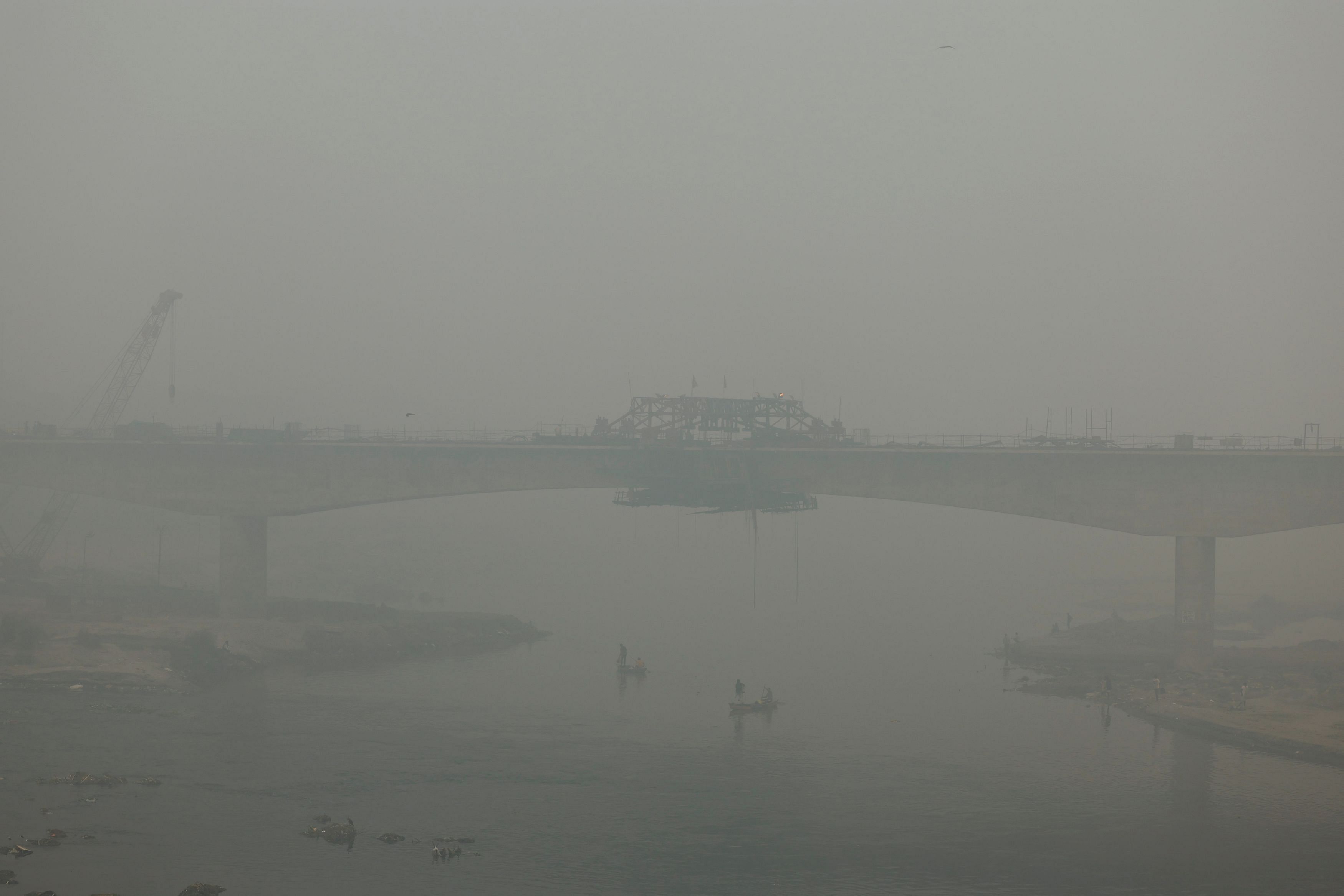 People ride on a boat on the river Yamuna, as the sky is enveloped with smog after Delhi's air quality turned "hazardous" due to alarming air pollution, in New Delhi, India, November 18, 2024. REUTERS/Anushree Fadnavis