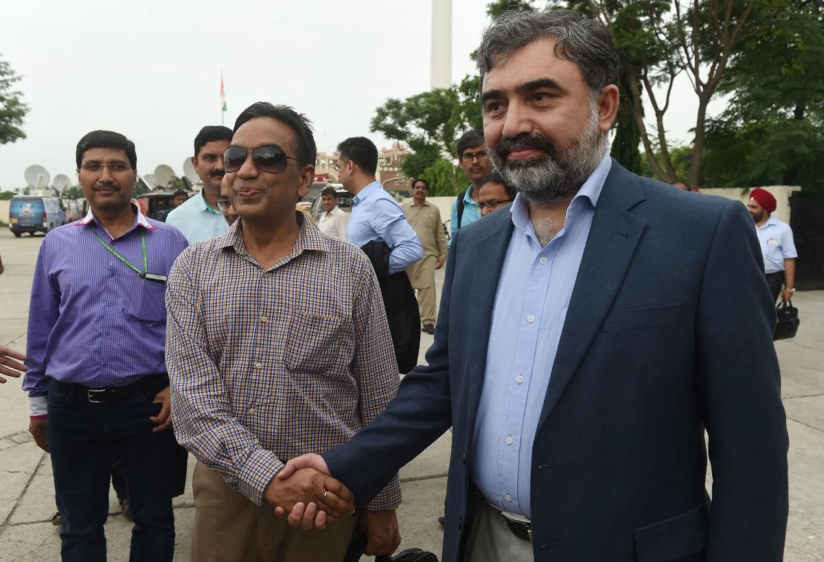 Pakistan's Commissioner for Indus Waters (PCIW) Syed Muhammad Mehar Ali Shah (R) shakes hands with Indian Indus Water Commissioner Pradeep Kumar Saxena (2L) on his arrival for a meeting to discuss Indus Waters Treaty and other issues, after crossing Wagah Border in Pakistan on August 28, 2018. (Photo by ARIF ALI / AFP)