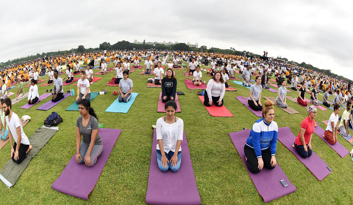 Large number of people take part in Mass Yoga programme, as part of 'International Yoga Day' celebration, organised by Mysuru District administration, at Race Course in Mysuru on Thursday. - PHOTO / SAVITHA B R