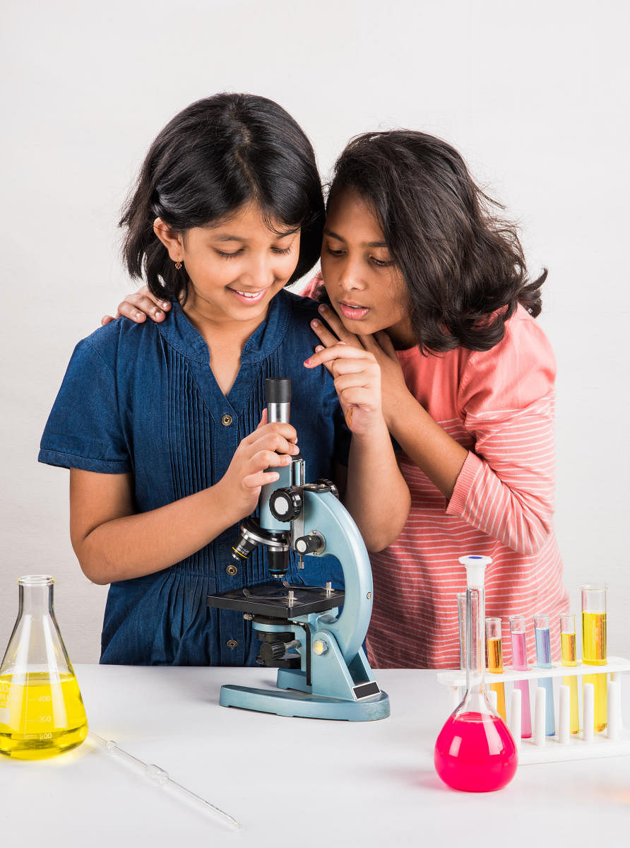 2 indian small girls doing science experiment, science Education. asian kids and science experiments, chemistry experiment, indian kids and science experiments, indian kids and science labscience Education