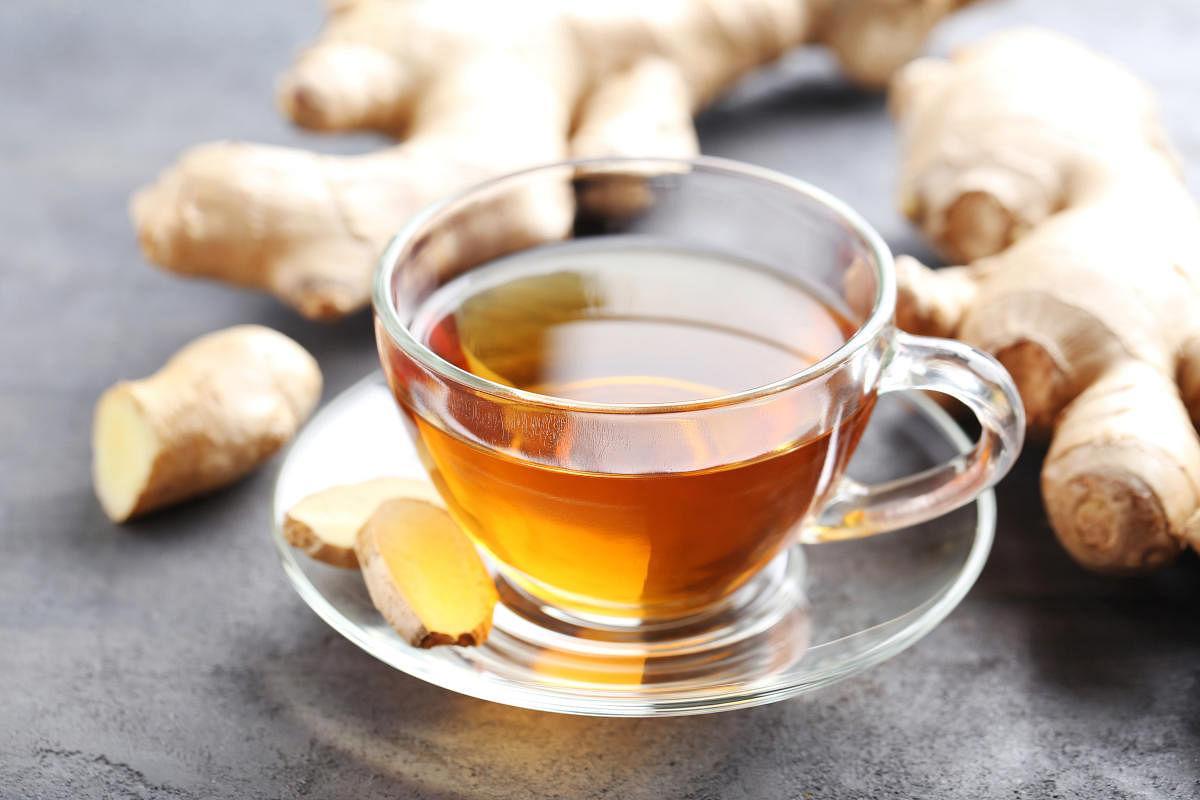 Cup of tea with ginger root on grey wooden tableGinger root, ginger powder and ginger tea