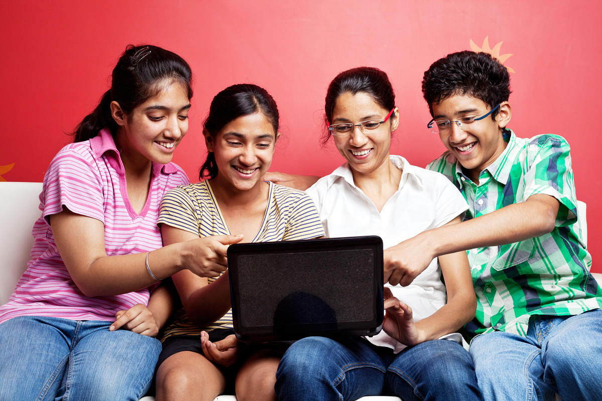 Indian Family with Mother and Teenage Boy Girls Using LaptopTeenager students in group discussion and group study.