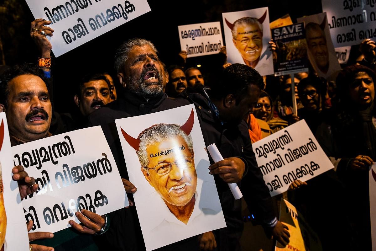 Indian Hindu activist hold placards bearing the image of Chief Minister of Kerala Pinarayi Vijayan and shout slogans outside Kerala State house, during a demonstration over two women entering the Sabarimala Ayyapa temple in the southern state of Kerala, in New Delhi on January 3, 2019. - Clashes broke out in southern India for a second day on January 3 as Hindu hardliners went on the rampage, seeking to enforce a general shutdown in protest at two women entering one of the country's holiest temples. A day after violence among rival groups and with police left one man dead and 15 people injured, authorities said that 266 protestors had been arrested across the state of Kerala. (Photo by CHANDAN KHANNA / AFP)